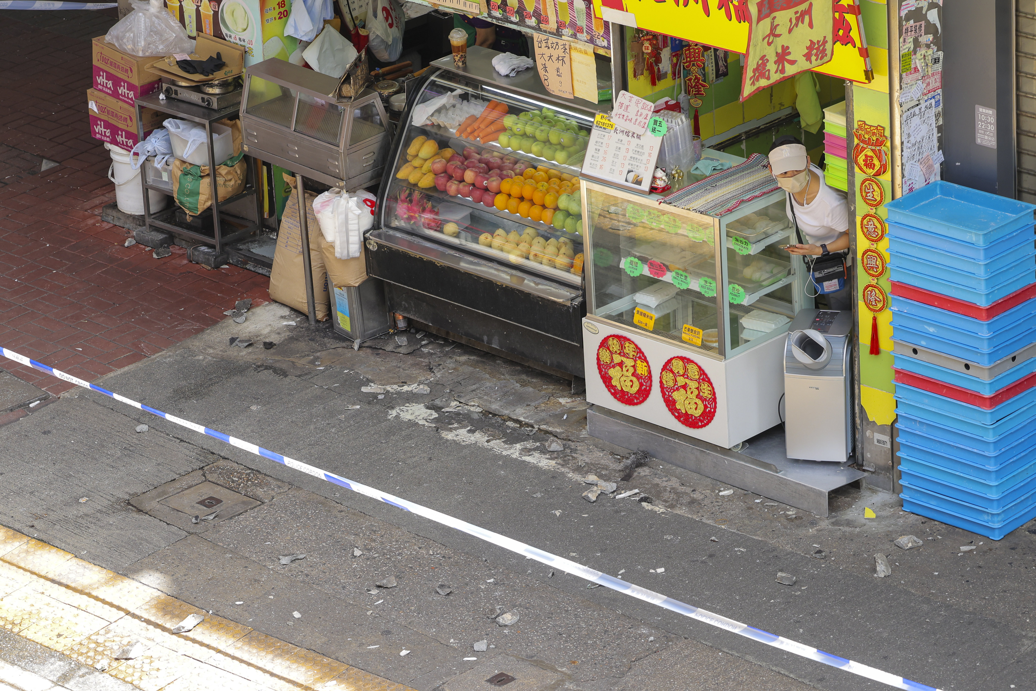 A shower of concrete is seen on the pavement outside the 57-year-old residential Po On Building in Mong Kok on July 5, the second such incident in three days. Some concrete pieces were as big as a fist. Photo: Jelly Tse