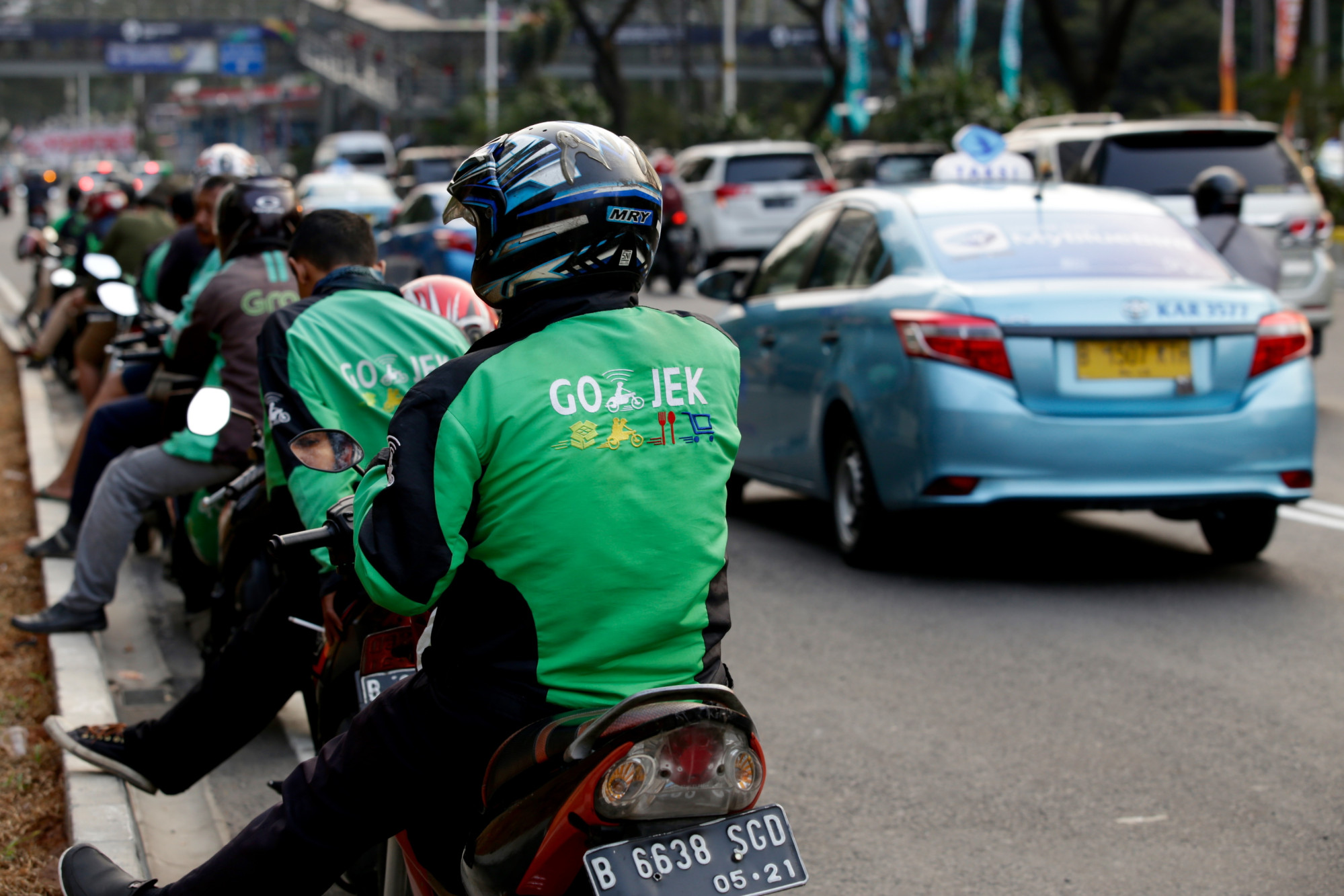 Gojek motorbike riders wait for passengers on the side of a Jakarta road. Photo: Shutterstock