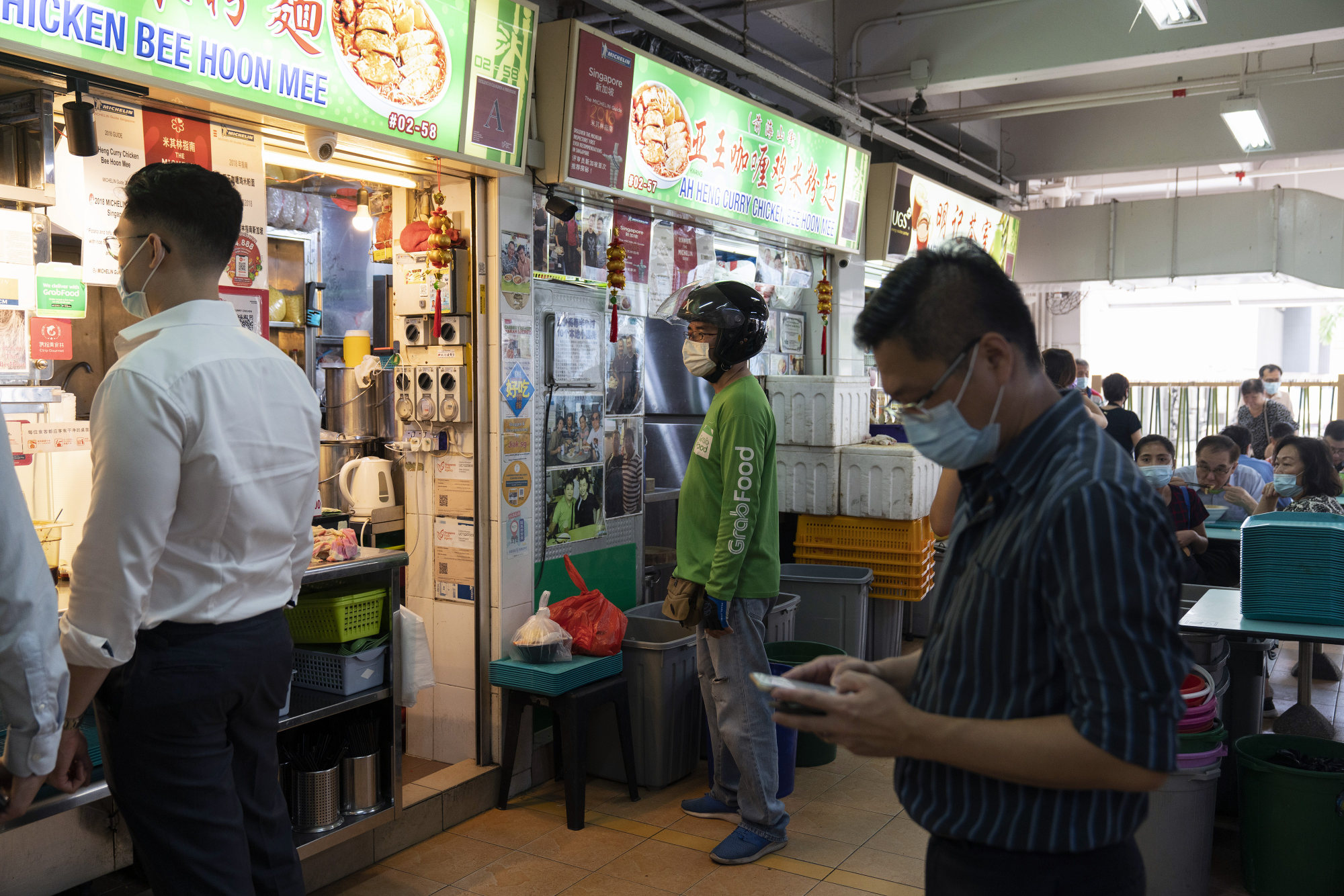 A gig worker in Singapore waits to pick up a GrabFood order. Singapore, the hub for Grab and Shopee, has shown a willingness to head off some of the issues emerging among app workers. Photo: Bloomberg