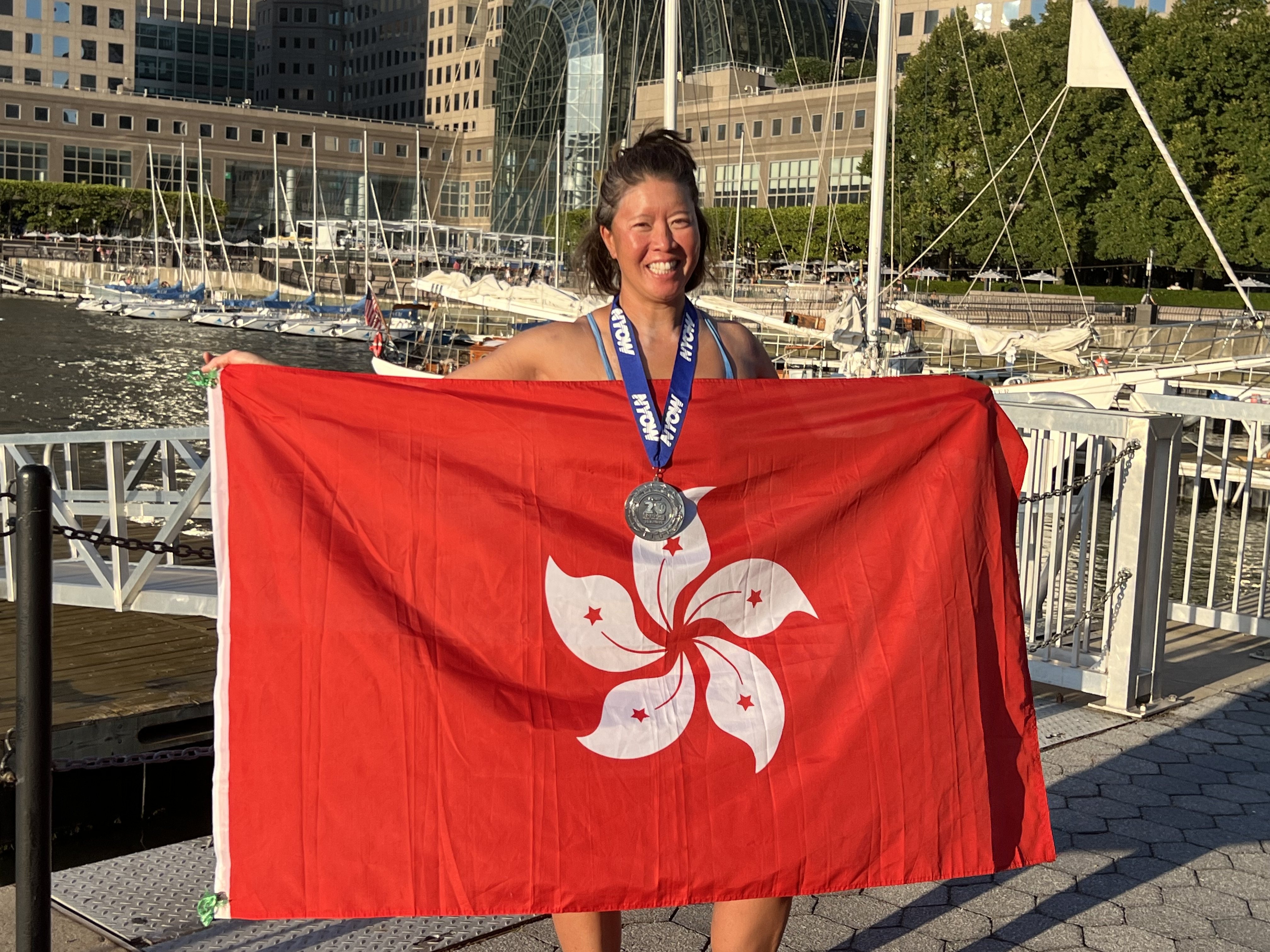 Edie Hu holds up a Hong Kong flag after swimming around Manhattan Island in the 20 Bridges challenge. Photo: Elizabeth Yuan
