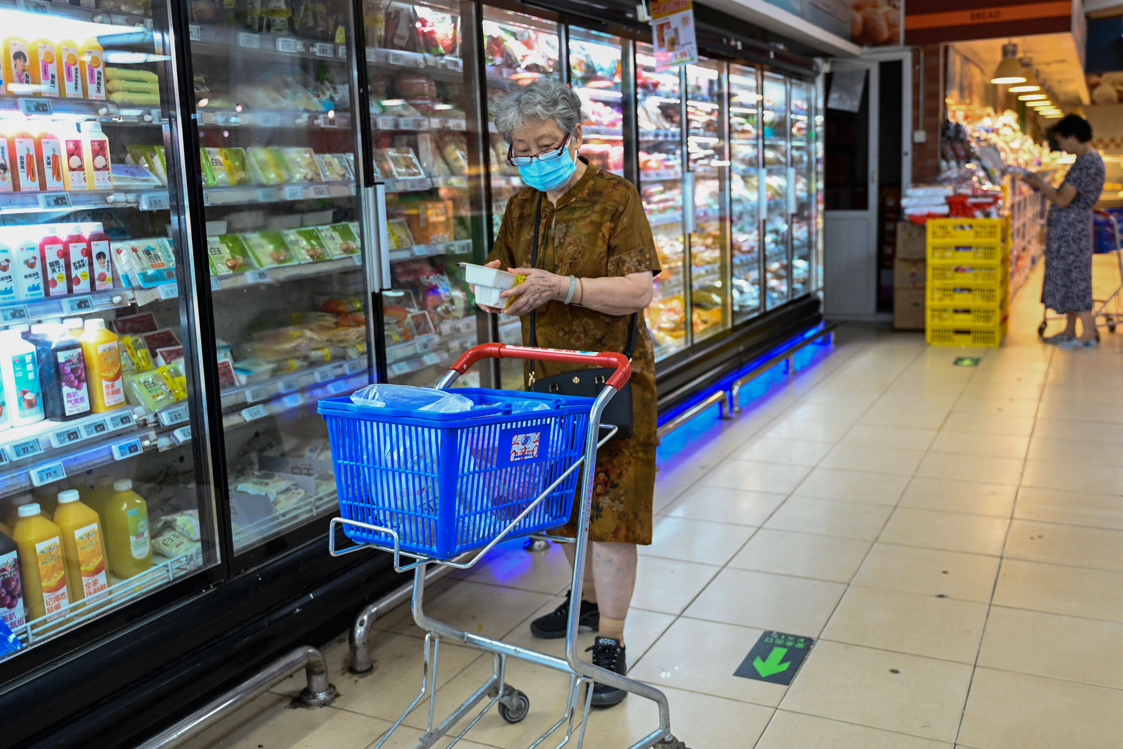A woman shops for frozen items at a supermarket in Beijing on August 13, 2023. Economic uncertainty has led many Chinese shoppers to change their habits, with more opting for domestically produced goods. Photo: AFP