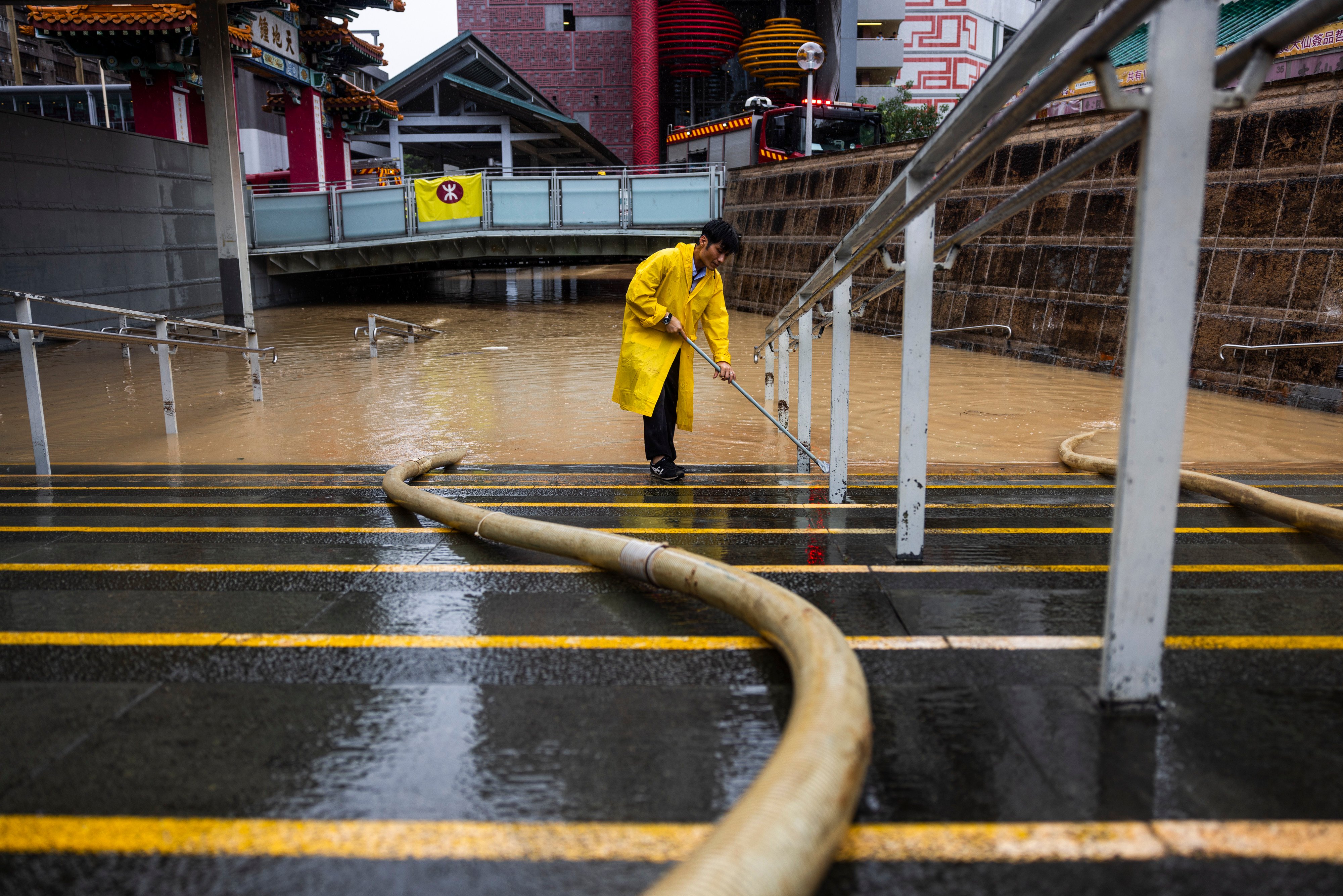 A worker clears water on a flooded street in Wong Tai Sin on September 8. Photo: AP 