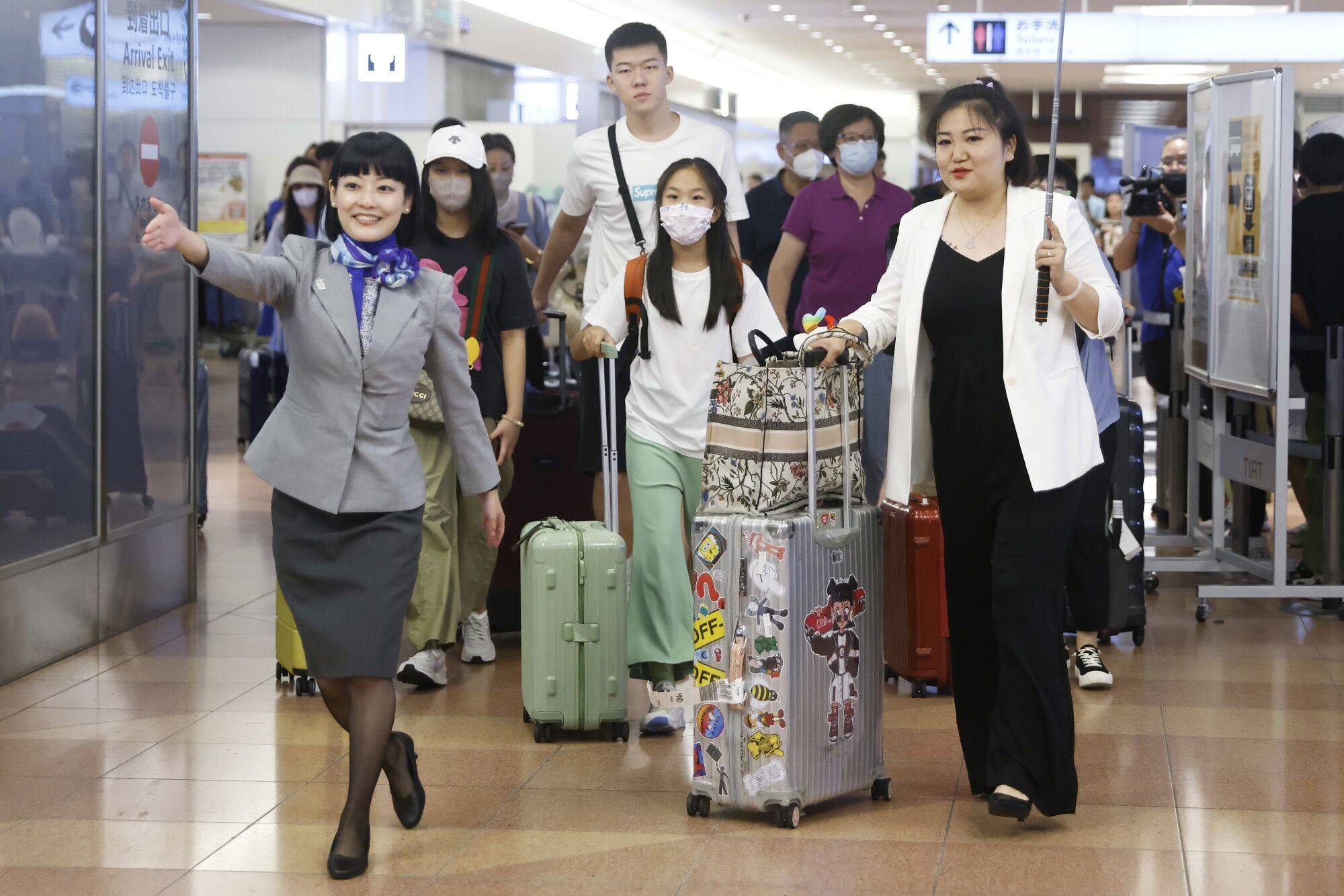 An All Nippon Airways employee escorts a Chinese tour group through Tokyo’s Haneda Airport in August. Tourist footfall that month was up 1,000 per cent year on year, according to the Japan Department Stores Association. Photo: Bloomberg