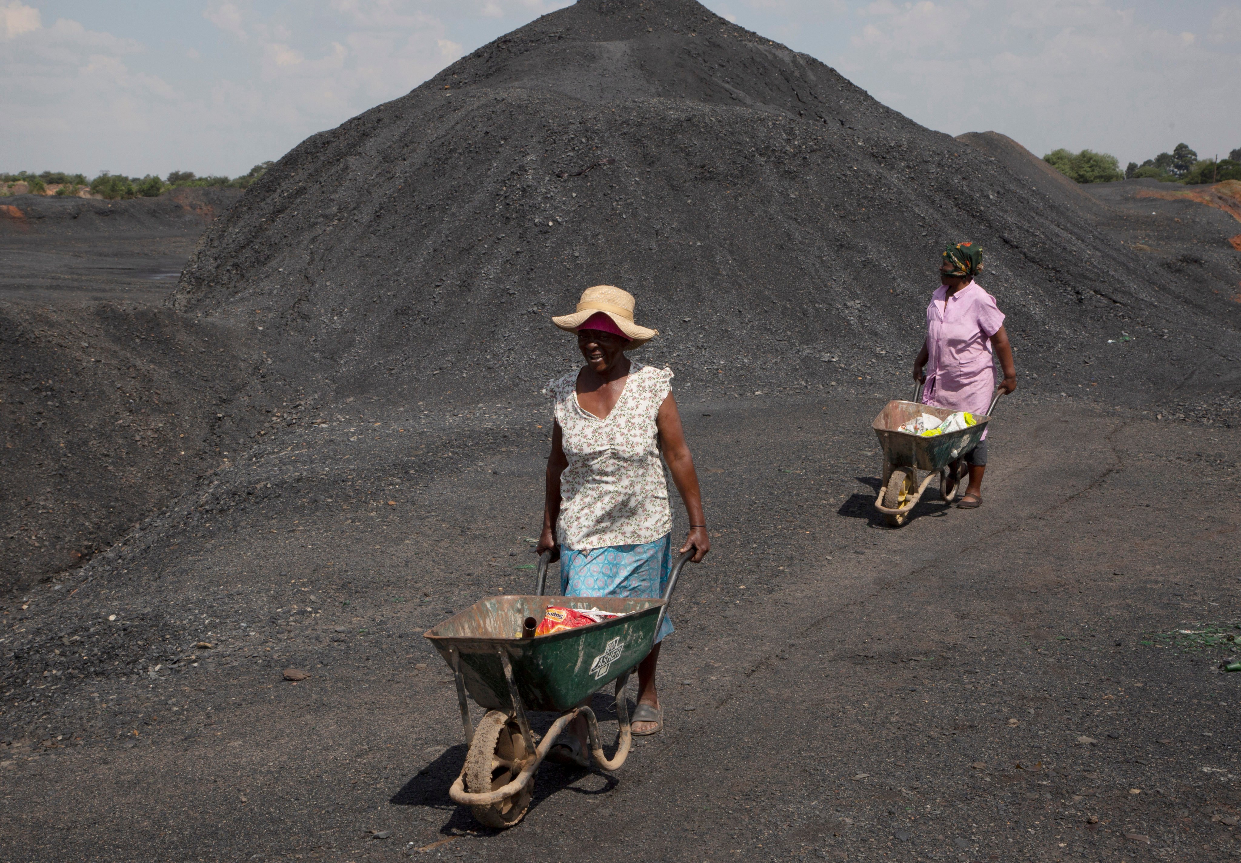 Women from the Masakhane township are seen on a coal mine dump at the coal-powered Duvha power station, near Emalahleni, east of Johannesburg, on November 17, 2022.  Living in the shadow of one of South Africa’s largest coal-fired power stations, locals fear job losses if the facility is closed as the country moves to cleaner energy. Photo: AP