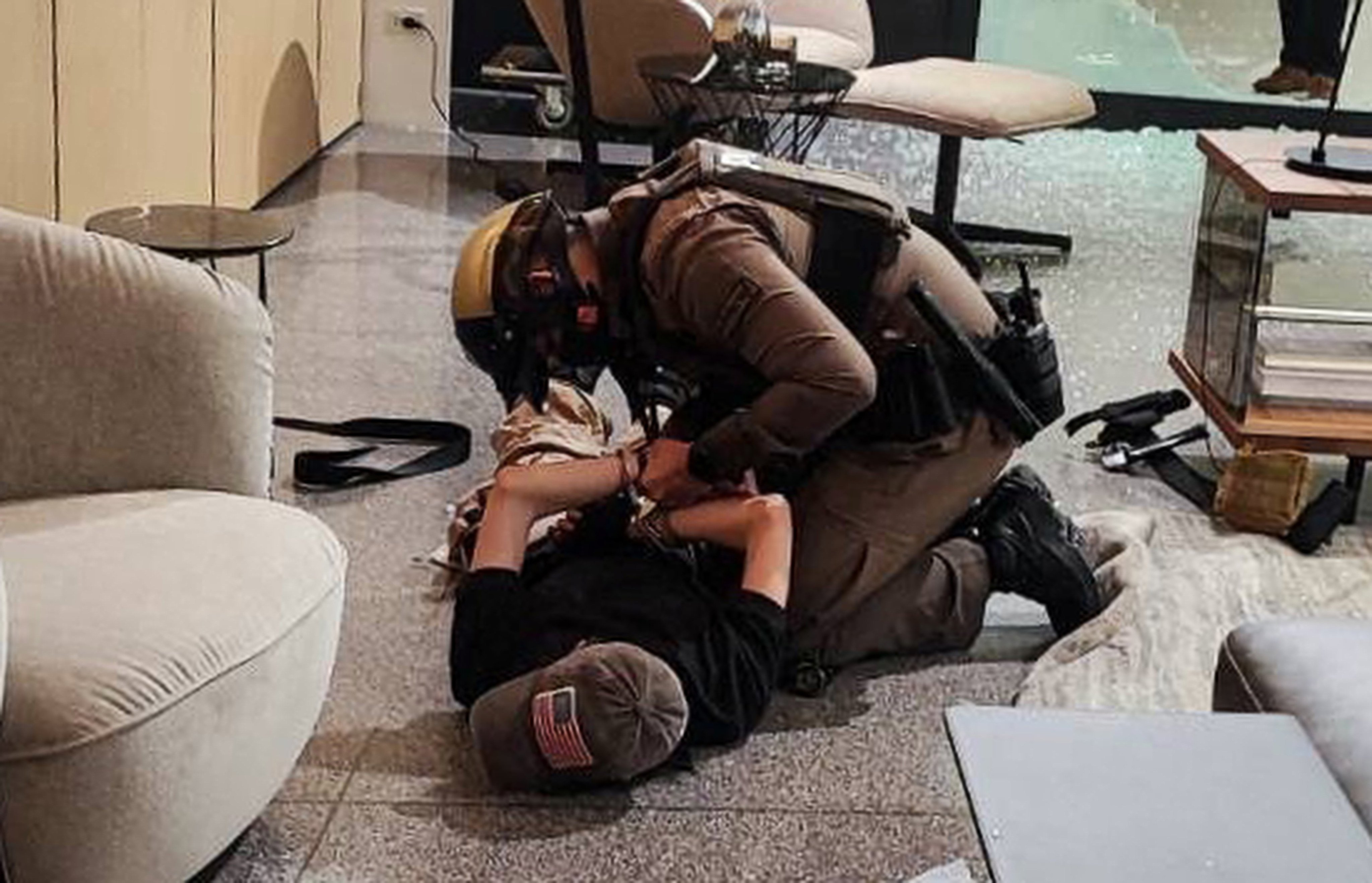 A suspect is detained following shots fired at the luxury Siam Paragon shopping centre. Photo: Reuters