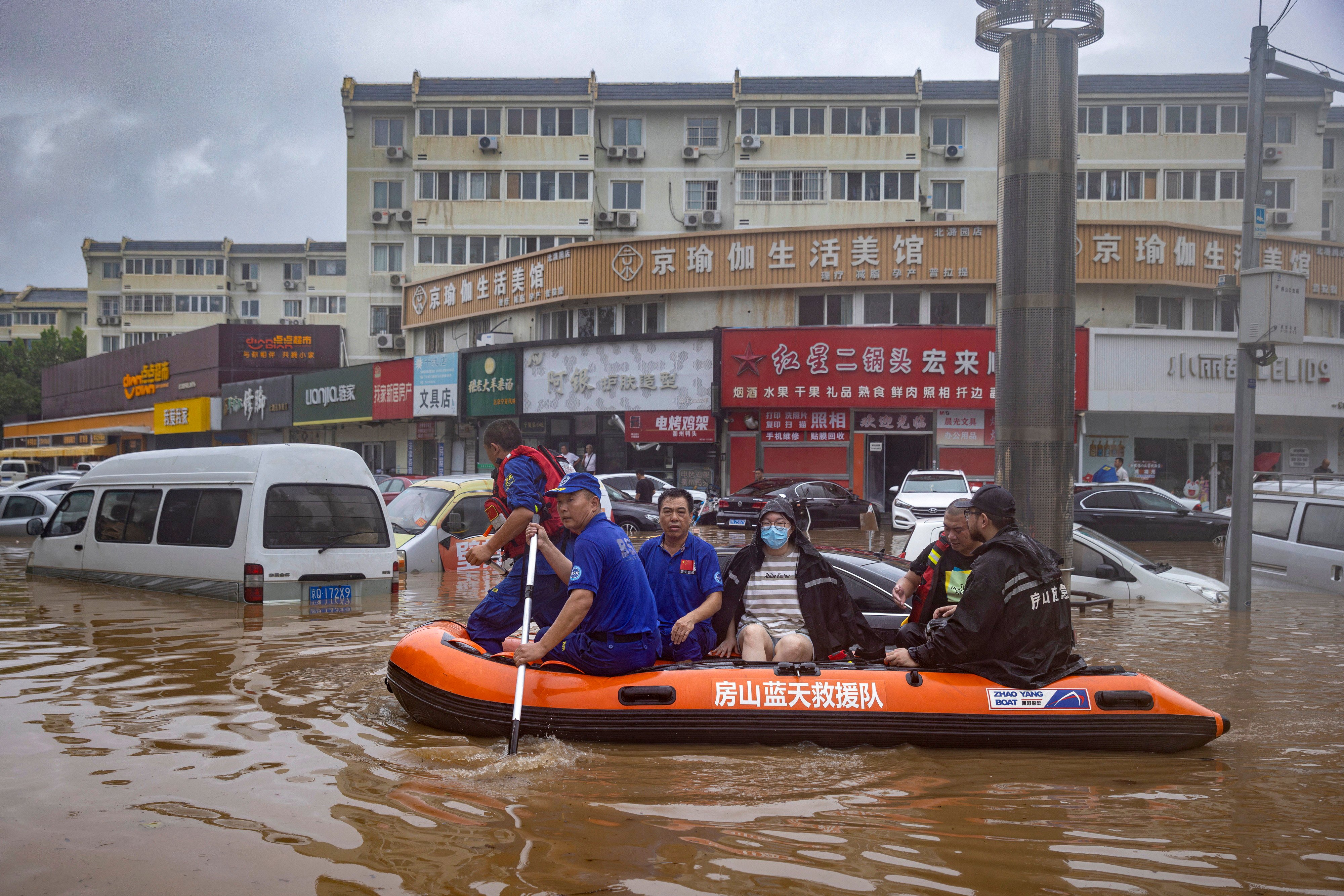 Rescuers paddle through a Beijing neighbourhood on August 1 after the Chinese capital was hit by heavy rain in the wake of Typhoon Doksuri. Photo: Reuters