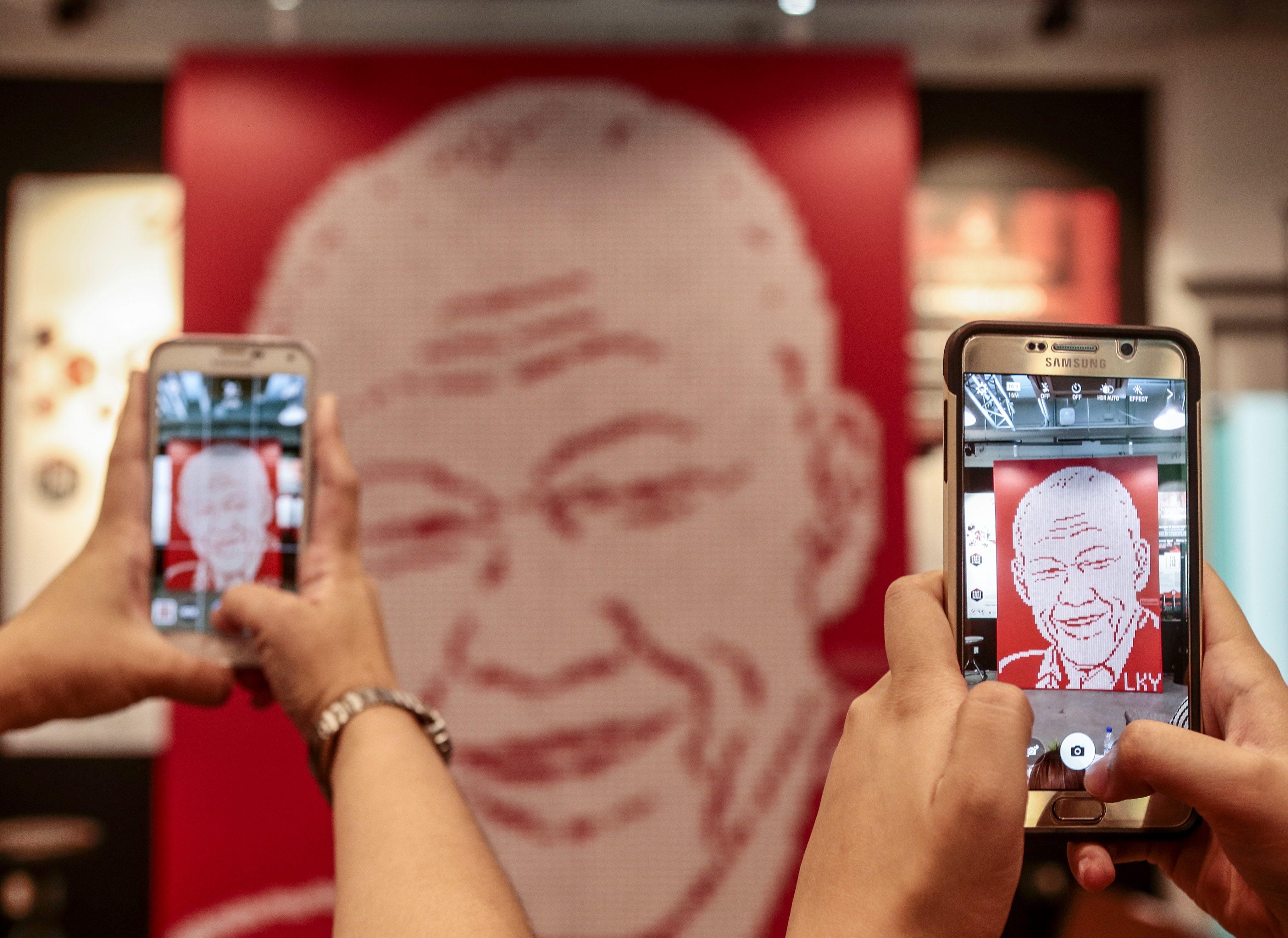 Visitors take photographs of a mural featuring the likeness of Lee Kuan Yew, during a tribute event in Singapore in 2016. The late political patriarch is said to have been vehemently opposed to having a personality cult growing around him. Photo: EPA