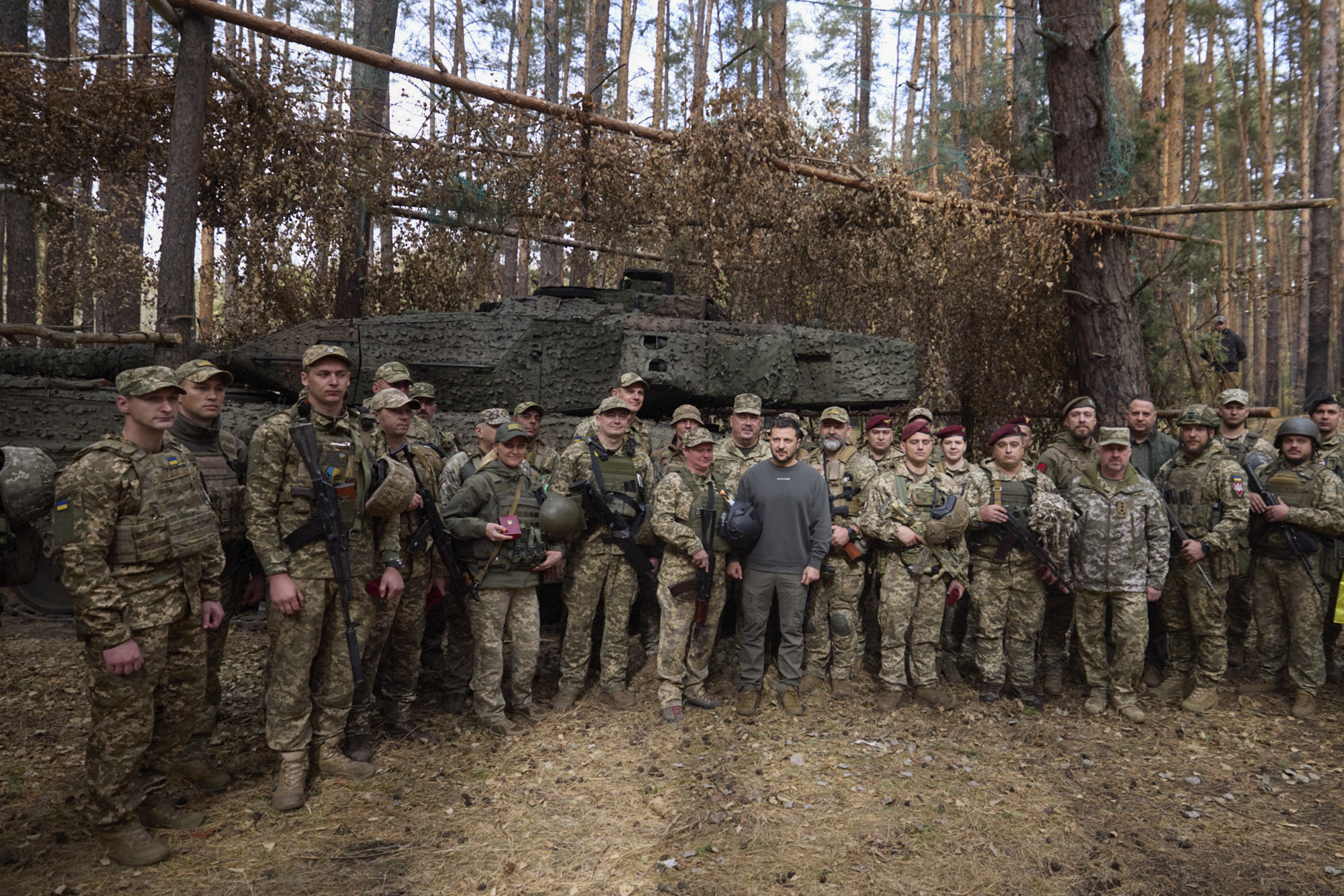 Ukrainian President Volodymyr Zelensky and Ukrainian soldiers in front of a Leopard 2 tank. Photo: Ukrainian Presidential Press Office via AP