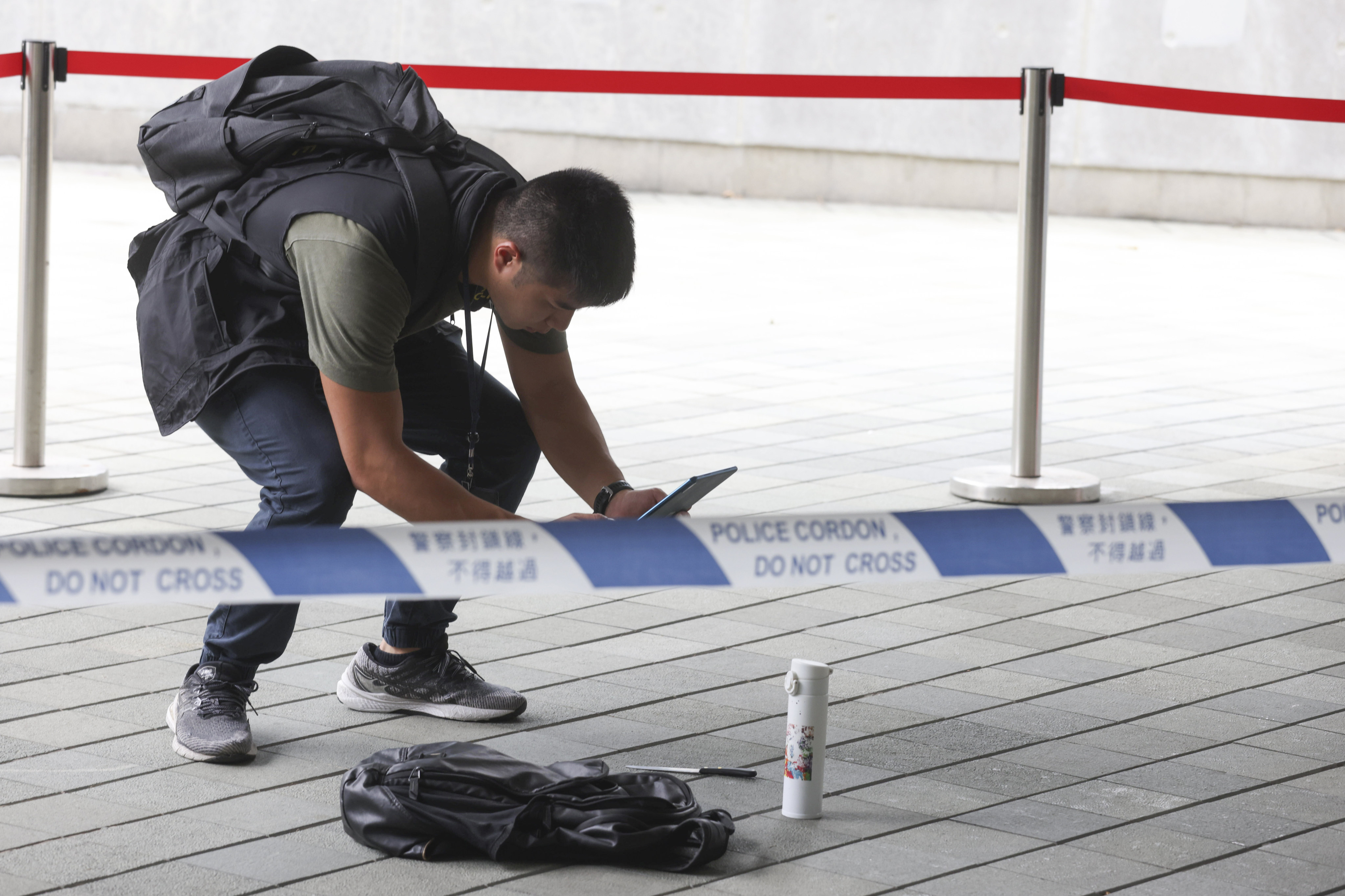 Police officers investigate the alleged attack at a guard post near the Tim Mei Avenue footbridge. Photo: Yik Yeung-man