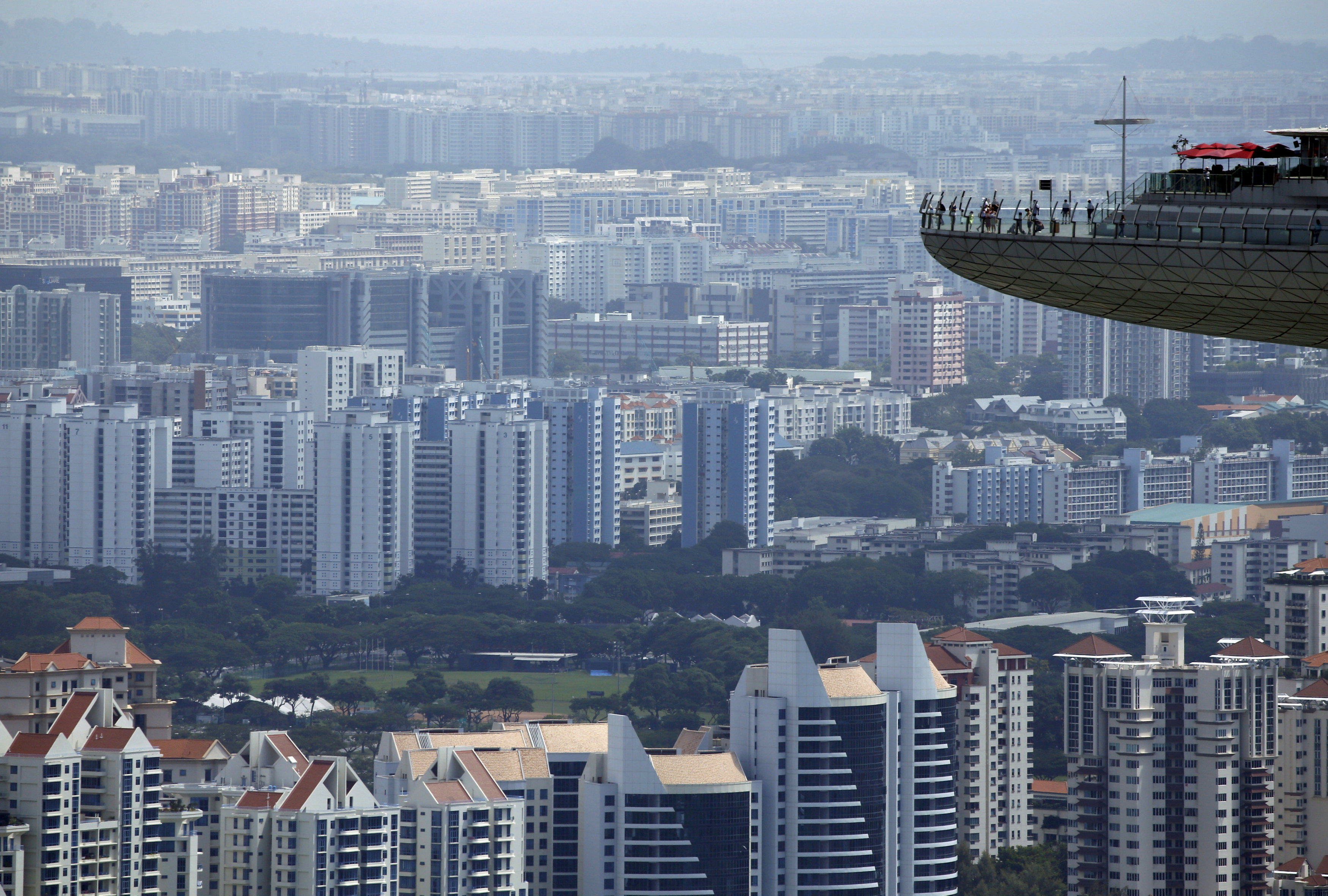 People look out from the observation tower of the Marina Bay Sands amongst public and private residential apartment buildings in Singapore on February 22, 2016. Economies of Southeast Asian nations are feeling the effects of China’s own slowdown. Photo: Reuters