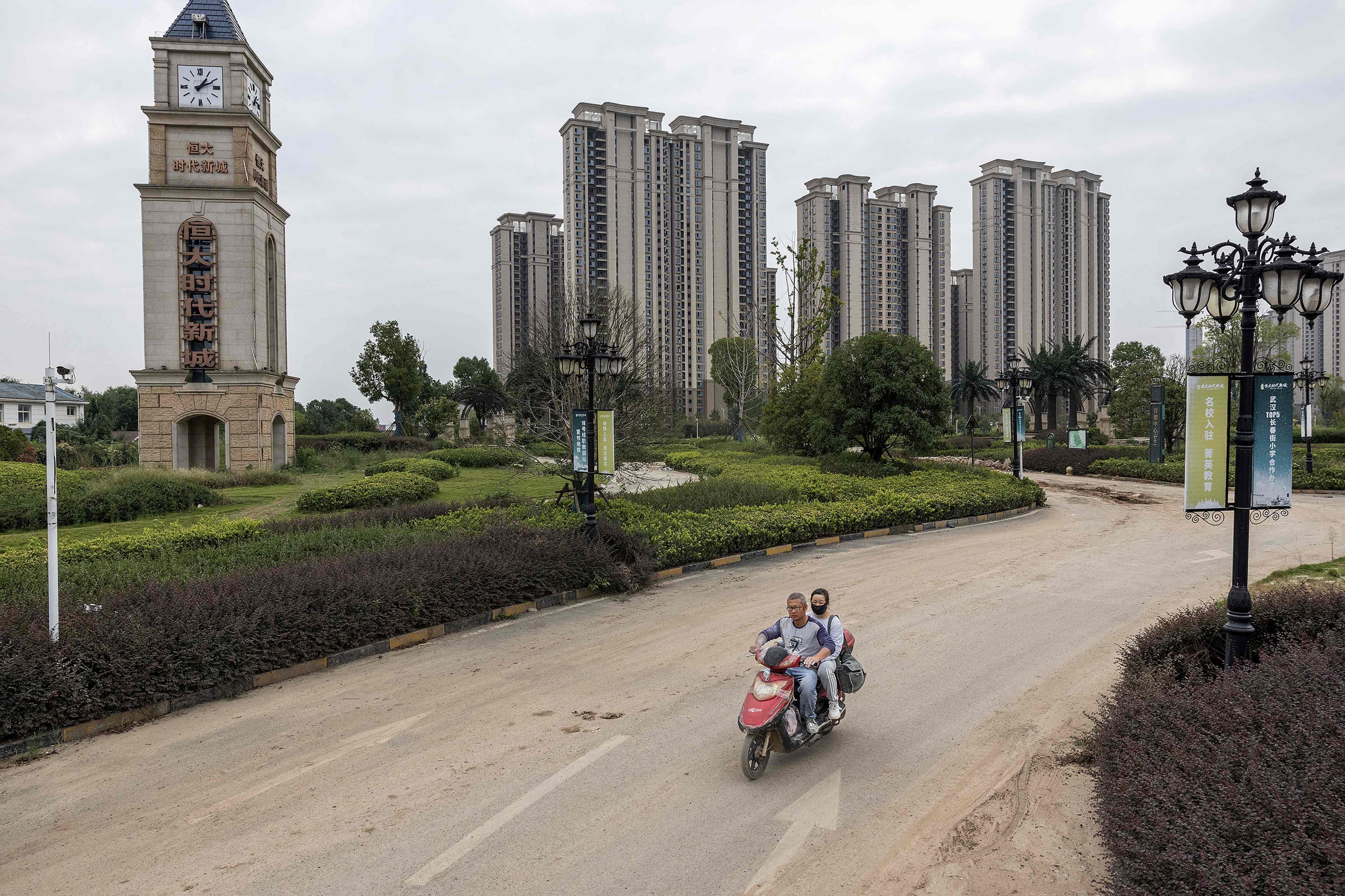 A man rides a scooter past a housing complex by Chinese property developer Evergrande in Wuhan, China’s central Hubei province, on September 28, 2023. Persistent weakness in the property sector is driving concerns about the country’s growth prospects. Photo: AFP