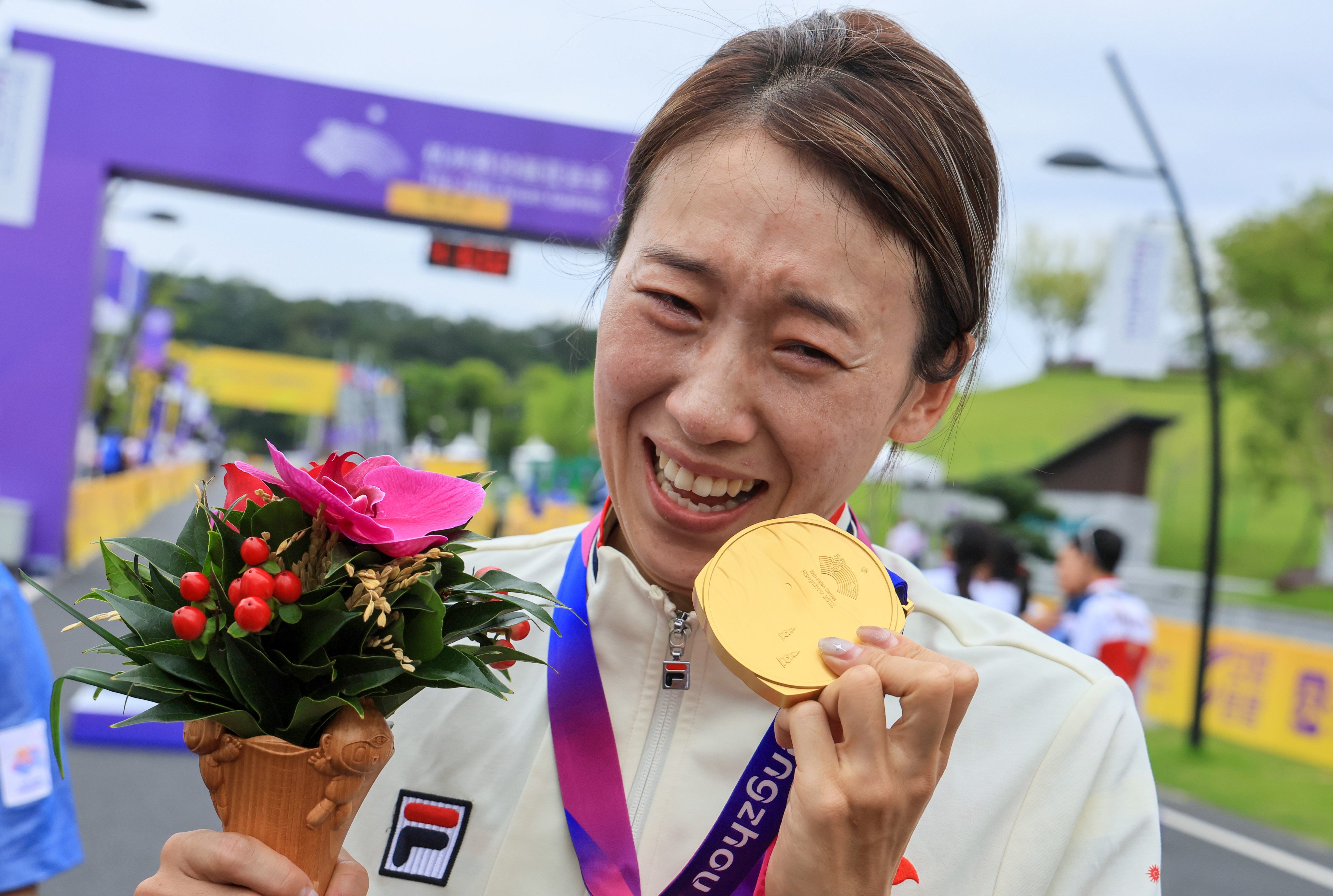 An emotional Yang Qianyu holds up her gold medal after winning the women’s road race. Photo: Dickson Lee.
