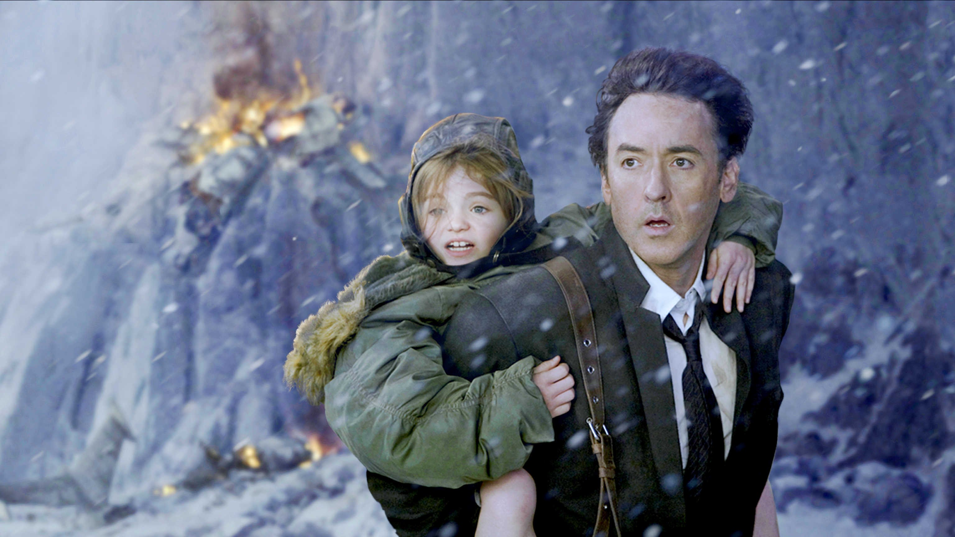 John Cusack as Jackson Curtis, a failed writer who tries to save his family as the world ends; and Morgan Lily as his daughter Lilly in a still from “2012”.