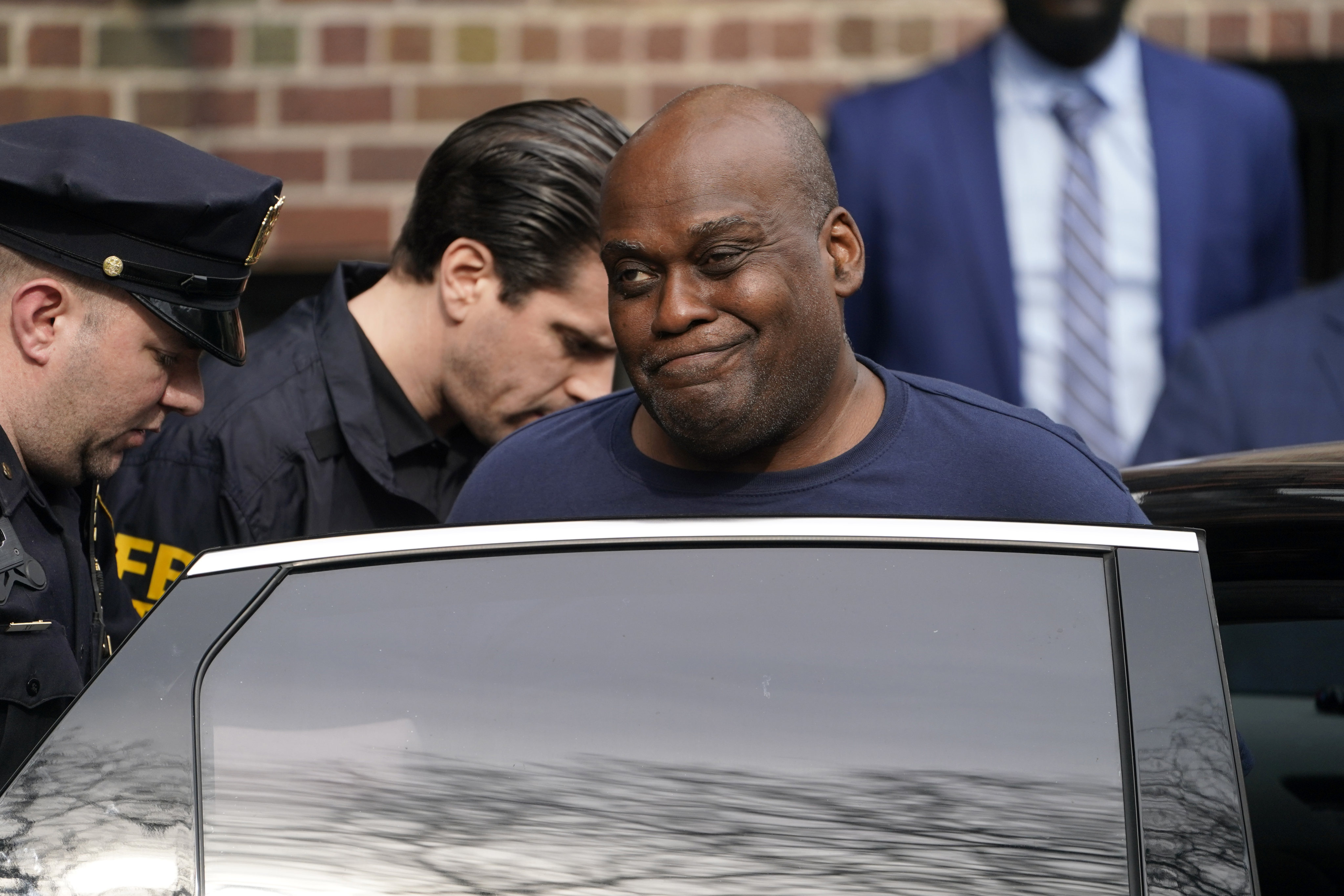 Law enforcement officials lead subway shooter Frank James away from a police station and into a vehicle in New York in April 2022. Photo: AP