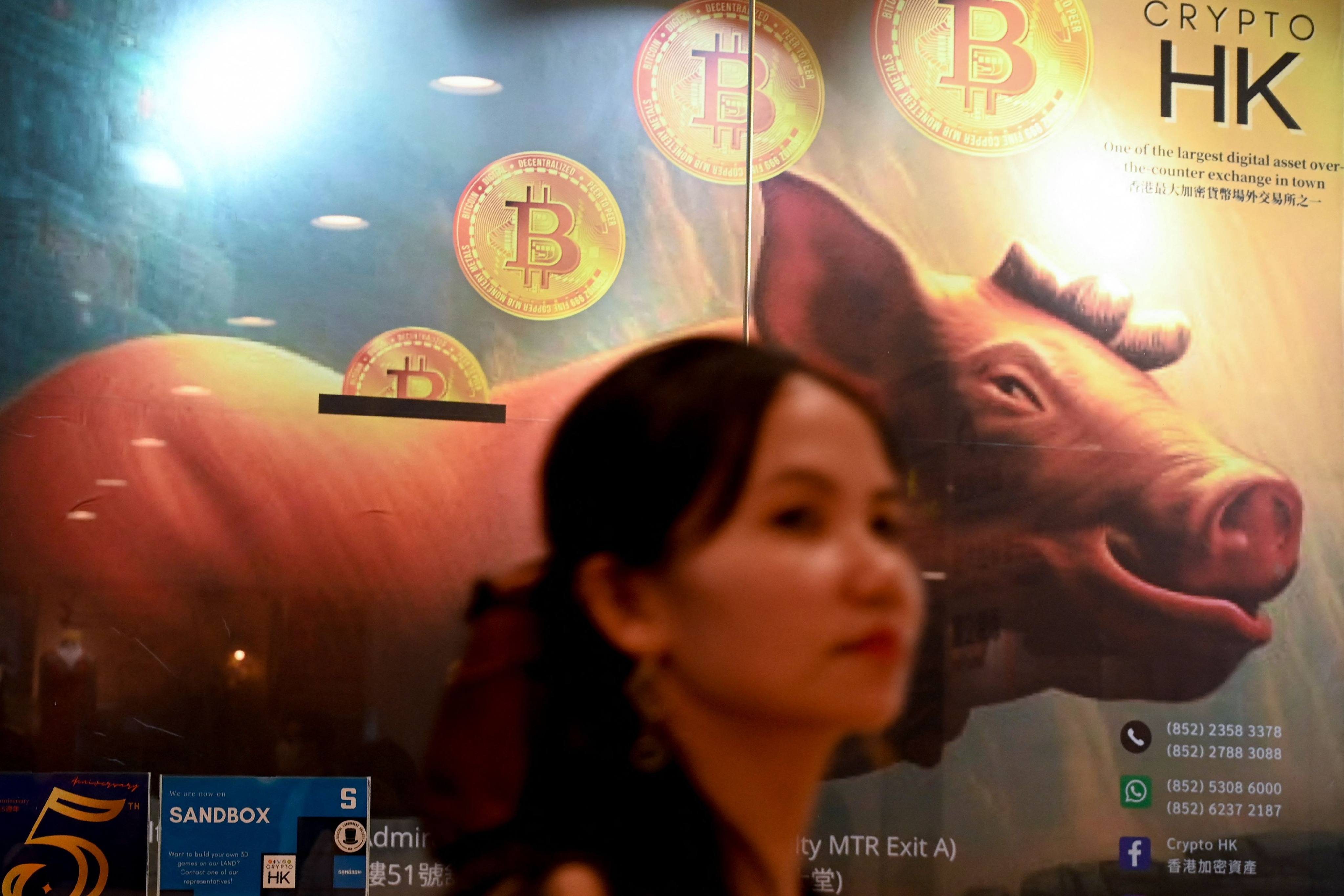 A woman passes a cryptocurrency exchange office in Hong Kong on May 27. Photo: AFP