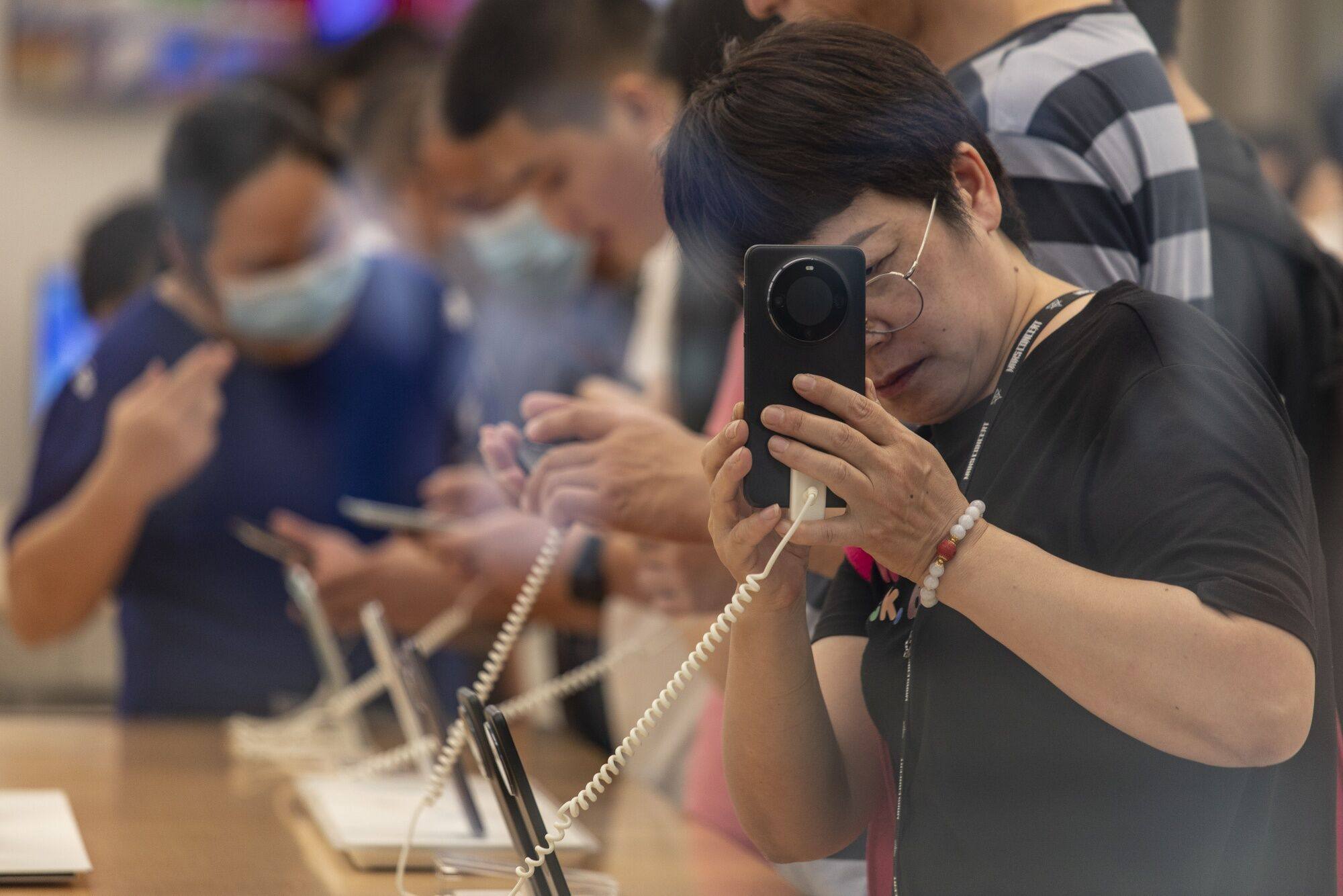 Shoppers try out smartphones on display inside a Huawei Technologies’ store in Shanghai. Photo: Bloomberg