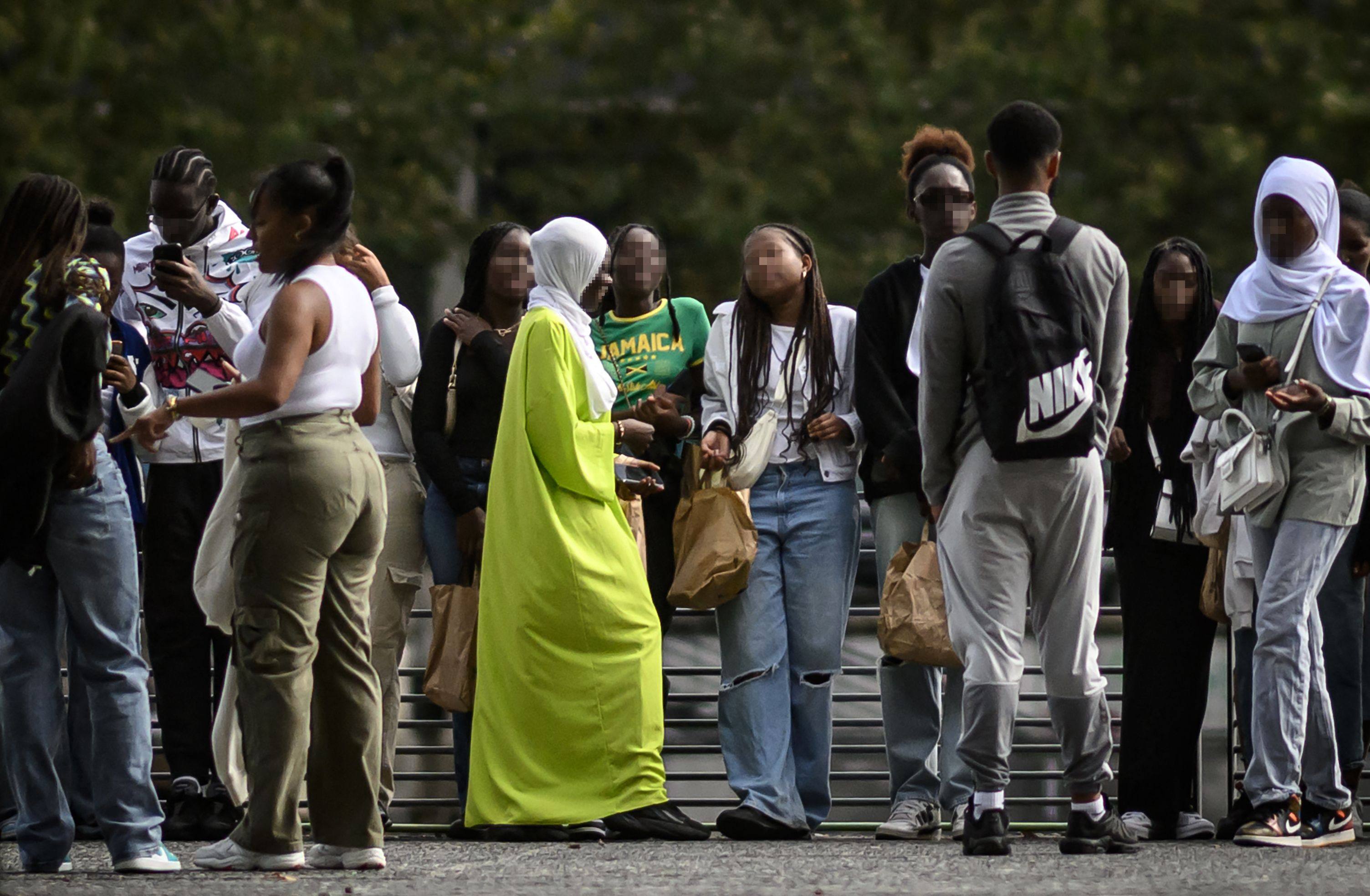 A young woman wearing an Abaya speaks with others on a street in Nantes, western France. Many critics argue that the abaya is a cultural garment, not a religious one. Photo: AFP