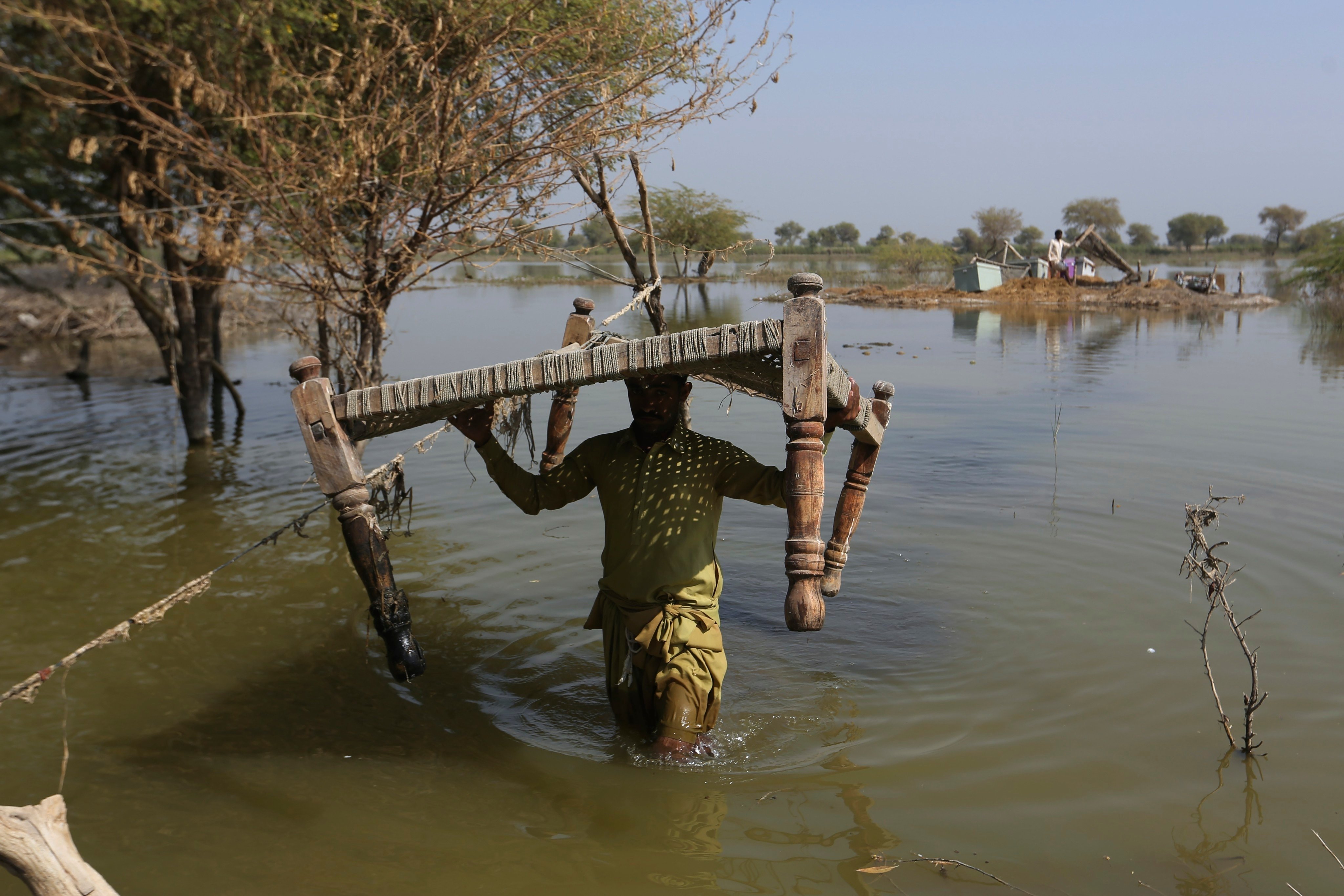 Villagers retrieve belongings in Sohbat Pur, a flood-hit district of Baluchistan province in Pakistan, on October 25, 2022. The rich world’s inaction on climate change is exacerbating environmental damage and social inequality in the developing world. Photo: AP