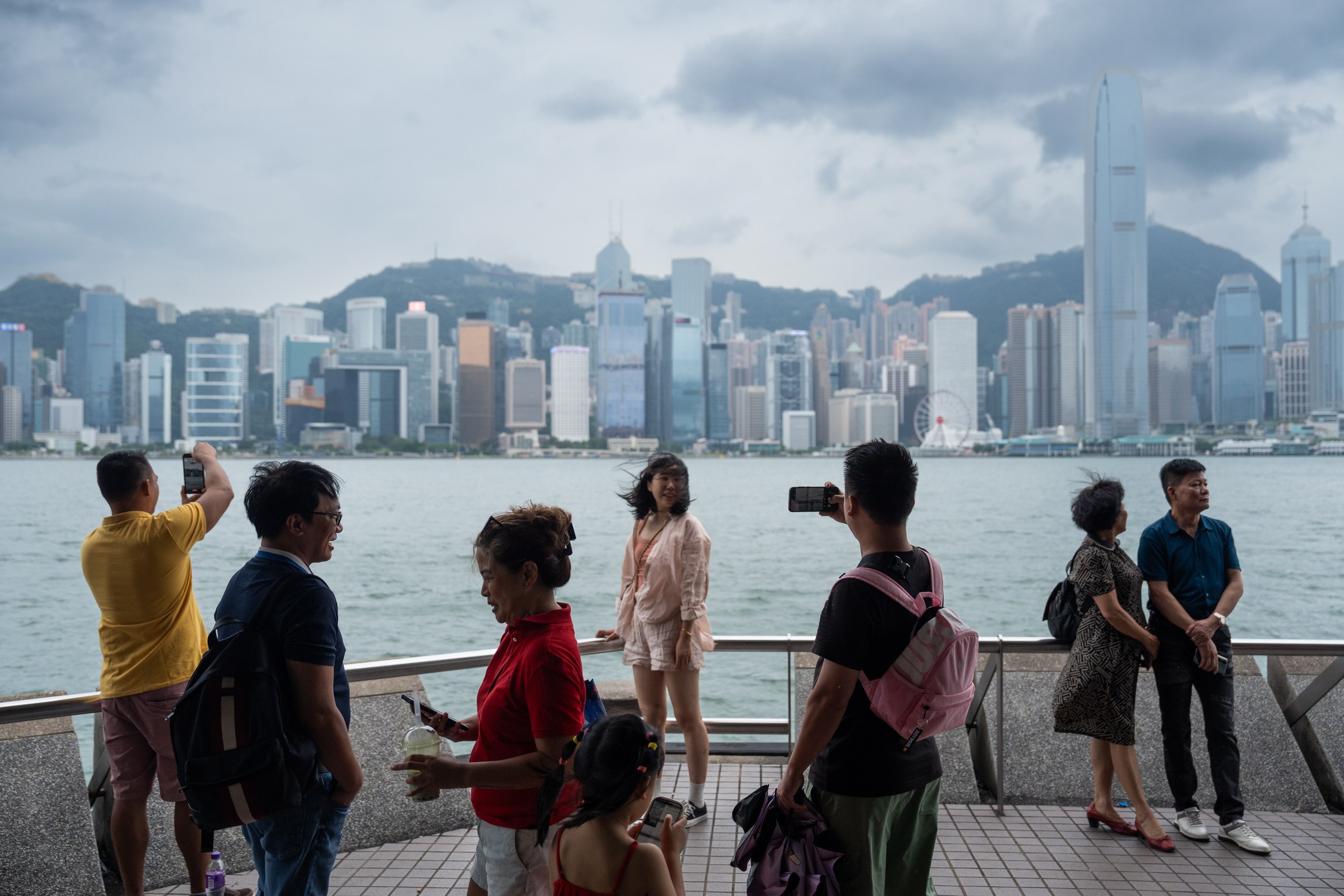 Tourists take photos in front of the Hong Kong island skyline during Typhoon Saola, on September 1. Photo: EPA-EFE