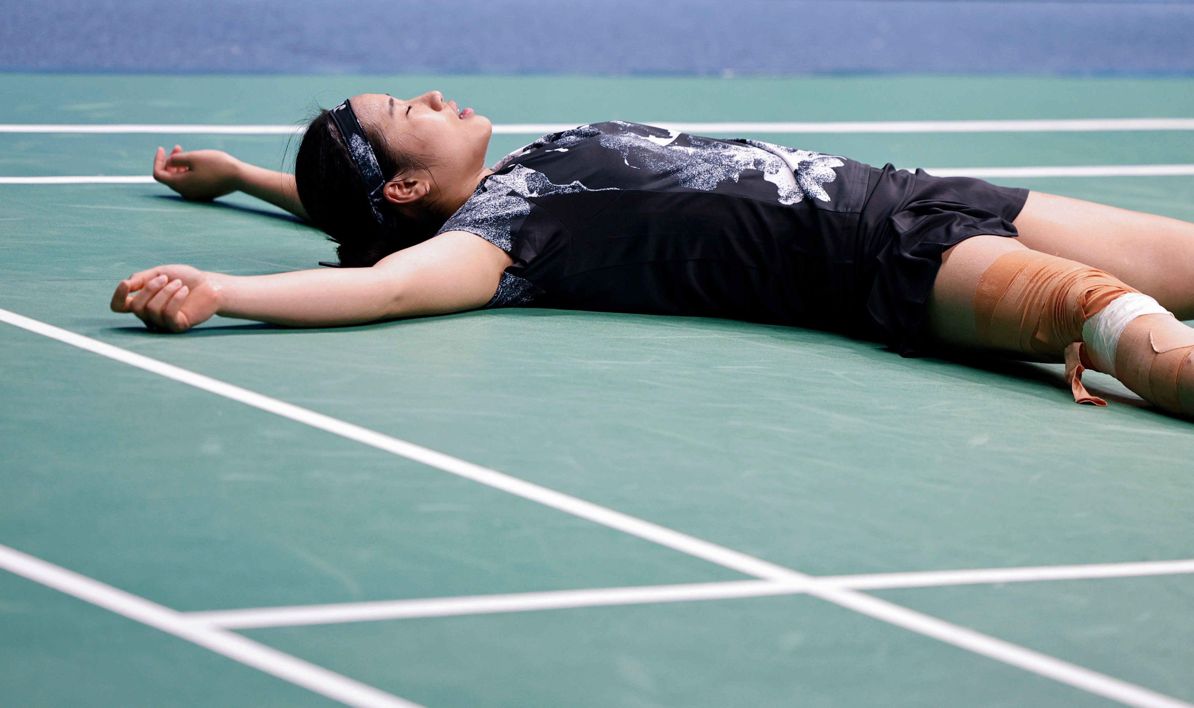 An Se-young of South Korea is exhausted after clinching women’s singles badminton gold in Hangzhou. Photo: Xinhua