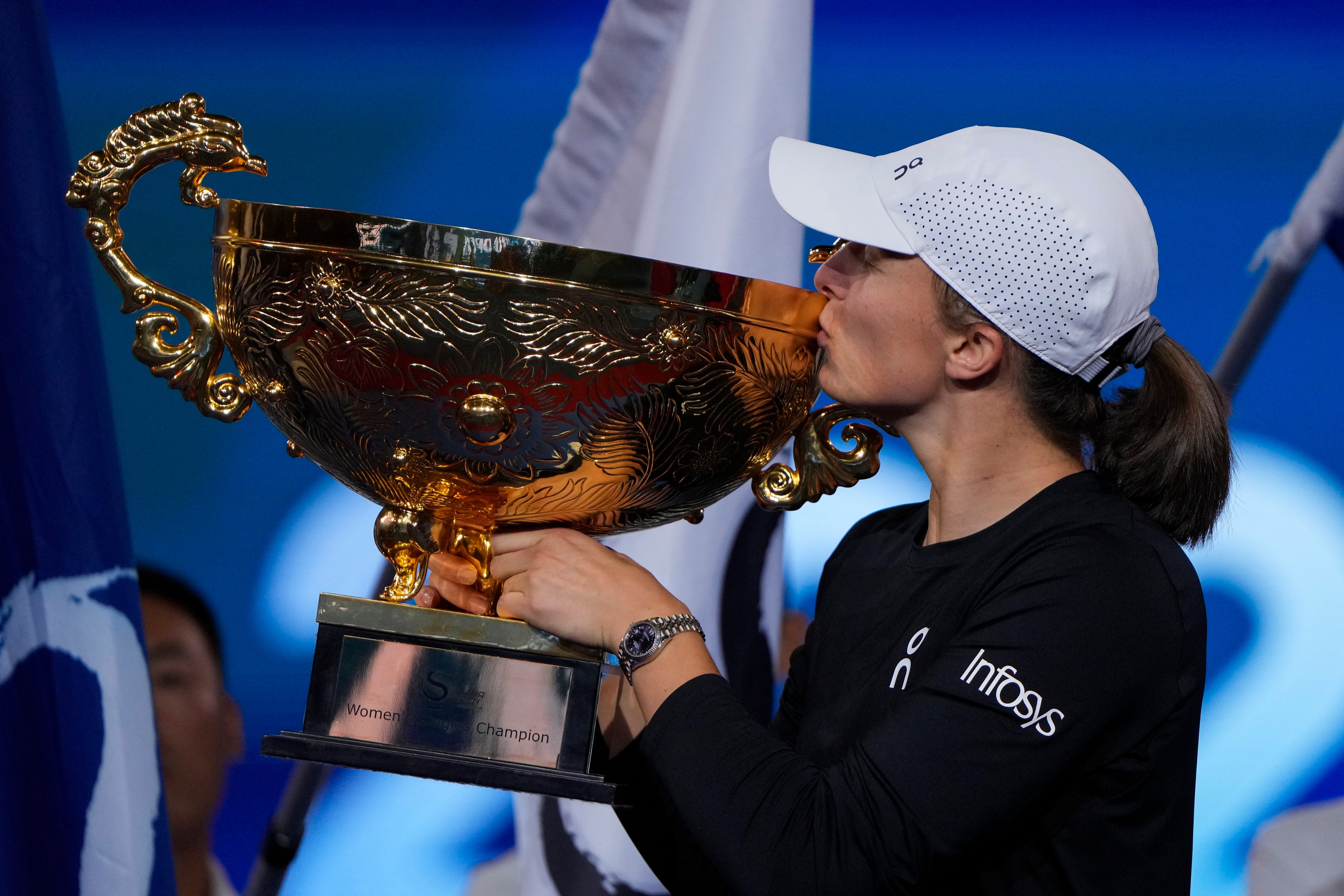 Iga Swiatek shows off her trophy after winning in Beijing. Photo: AP