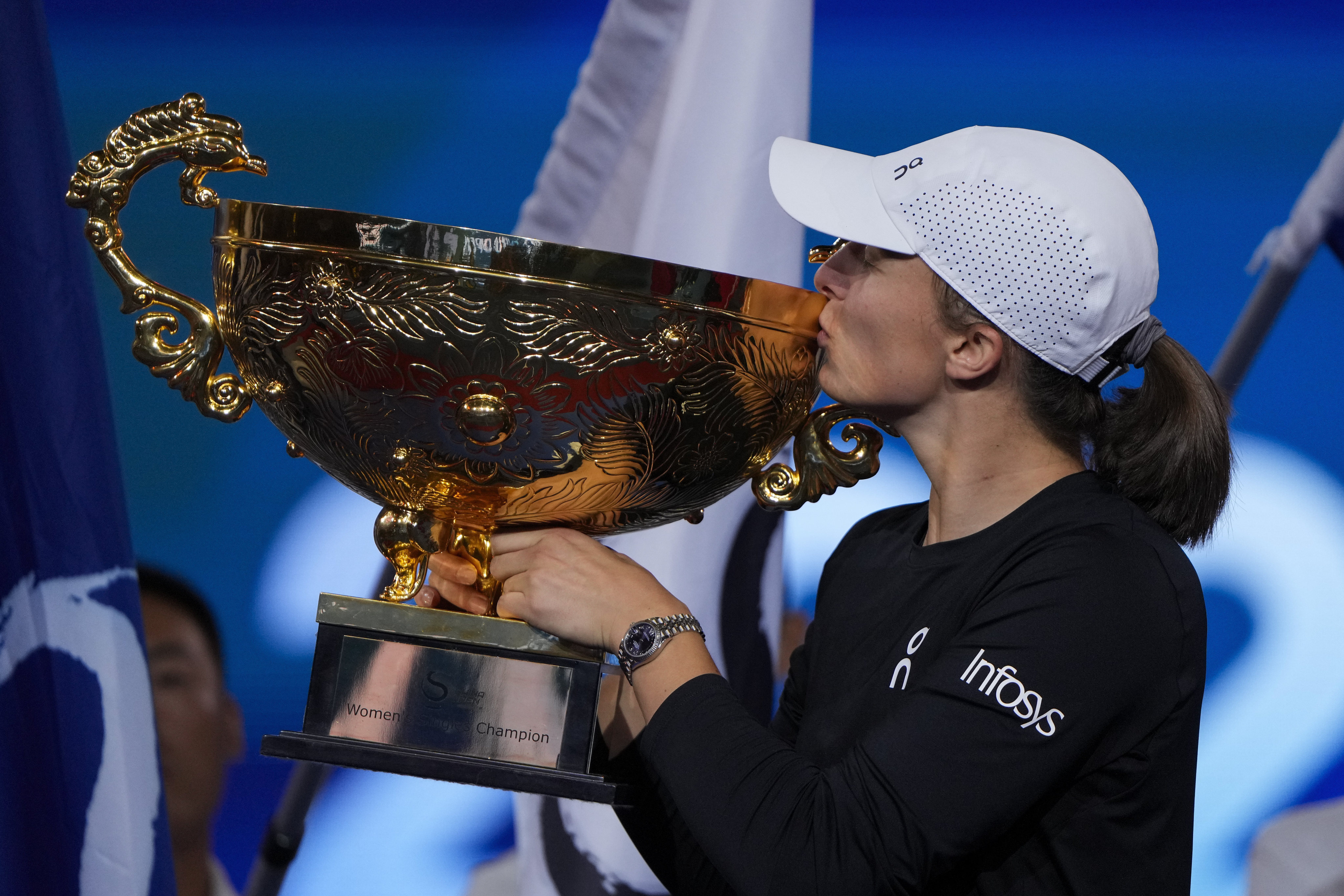 Iga Swiatek shows off her trophy after winning in Beijing. Photo: AP