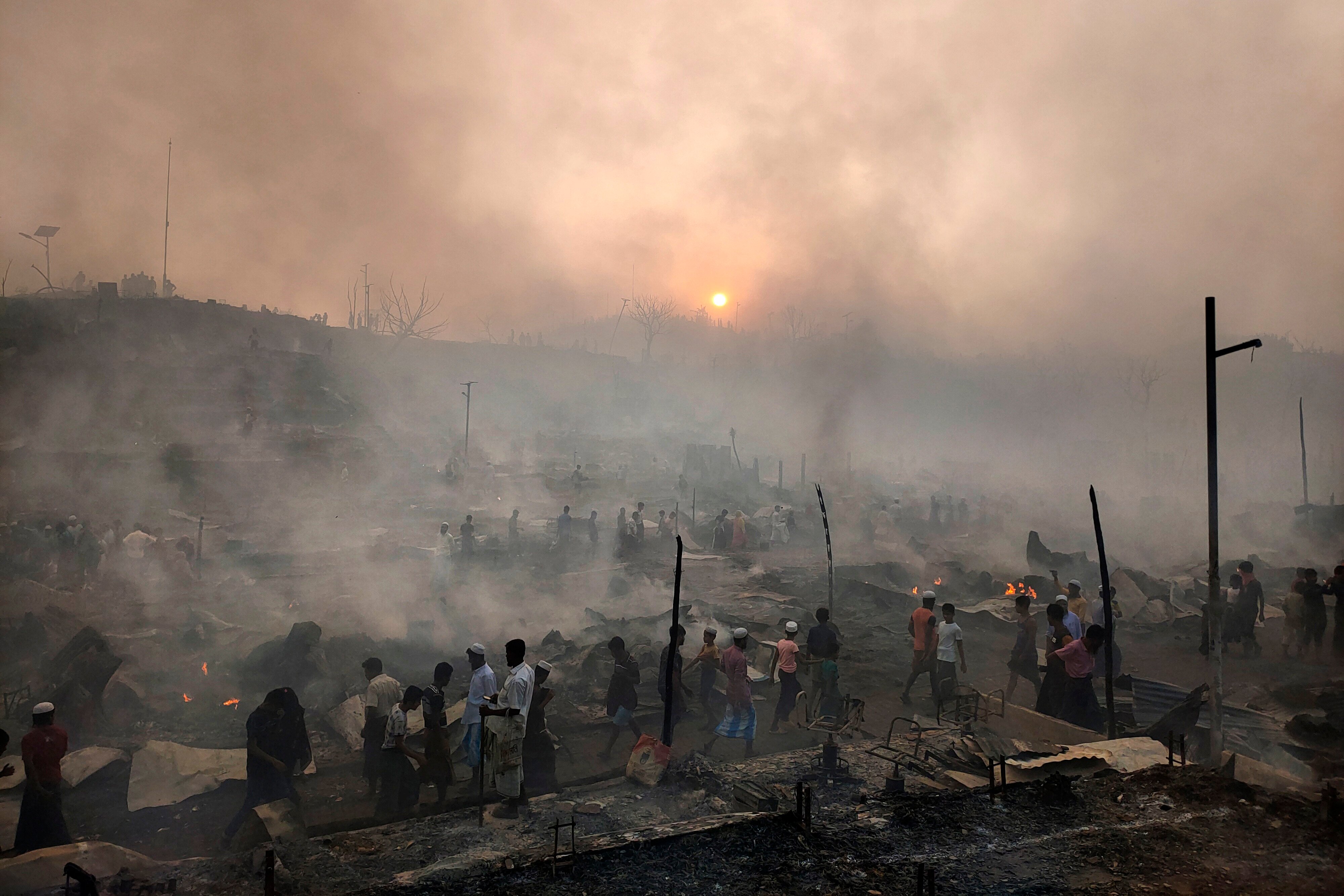 Rohingya refugees try to salvage their belongings after a major fire in a camp in Cox’s Bazar in March. Photo: AP