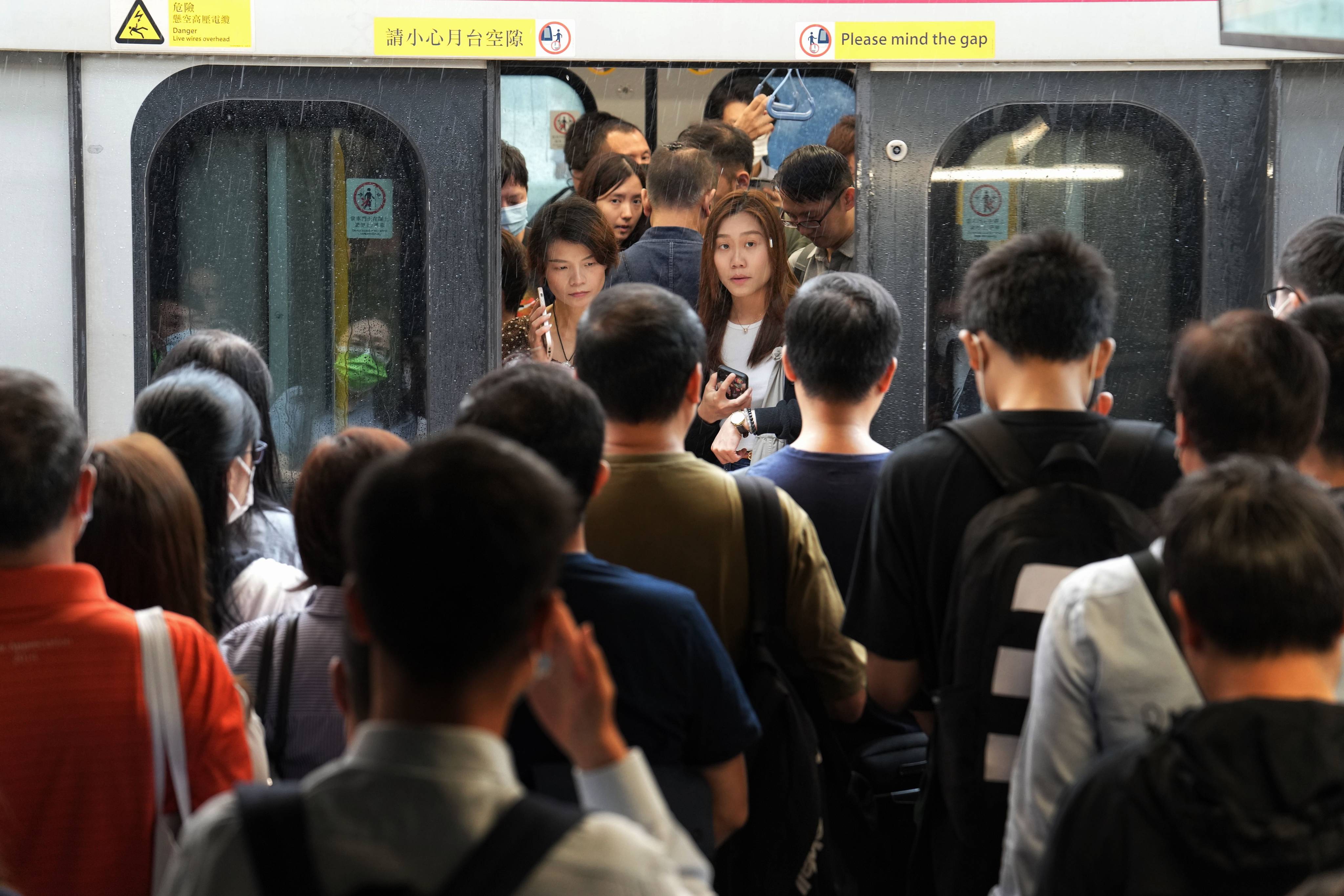 Commuters rush to catch a train at Tai Wai station after the city lowered the typhoon signal to No 3. Photo: Elson Li