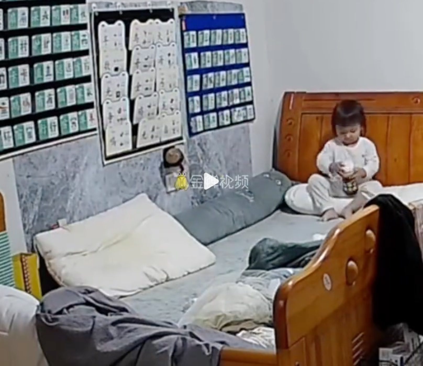 Surveillance camera footage shows the little girl sitting on a bed drinking from a bottle of milk. Photo: Douyin