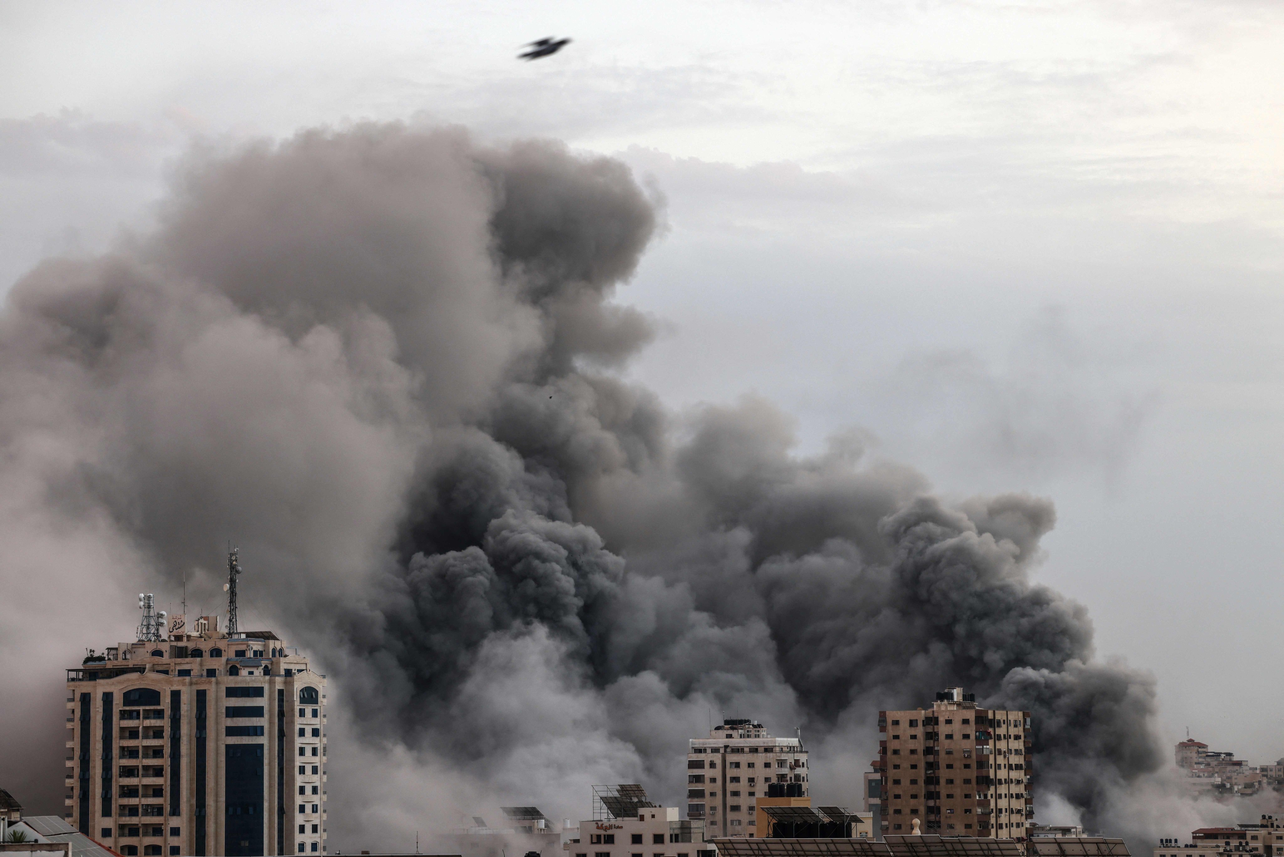Smoke billows behind high-rise buildings during an Israeli airstrike on Gaza City on October 9, 2023. Photo: AFP