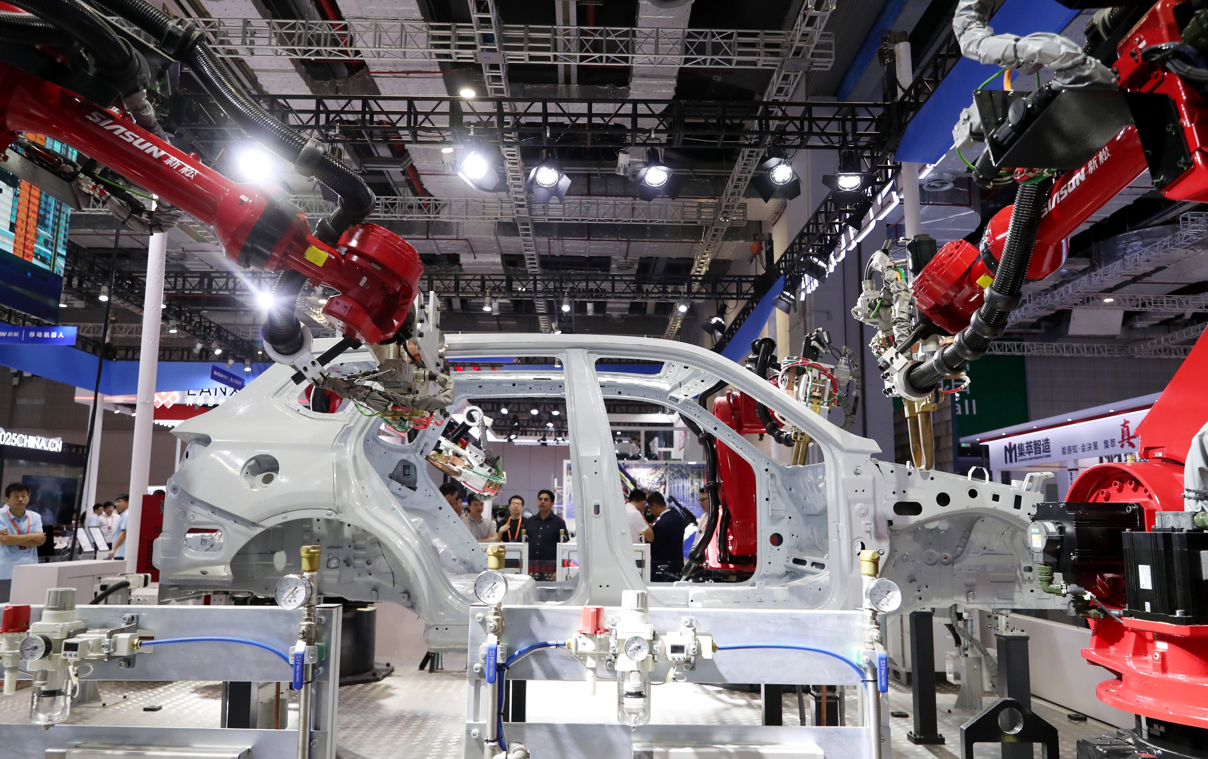 Visitors watch a robot perform welding on the body of a car at the China International Industry Fair in Shanghai on September 19. Photo: Xinhua