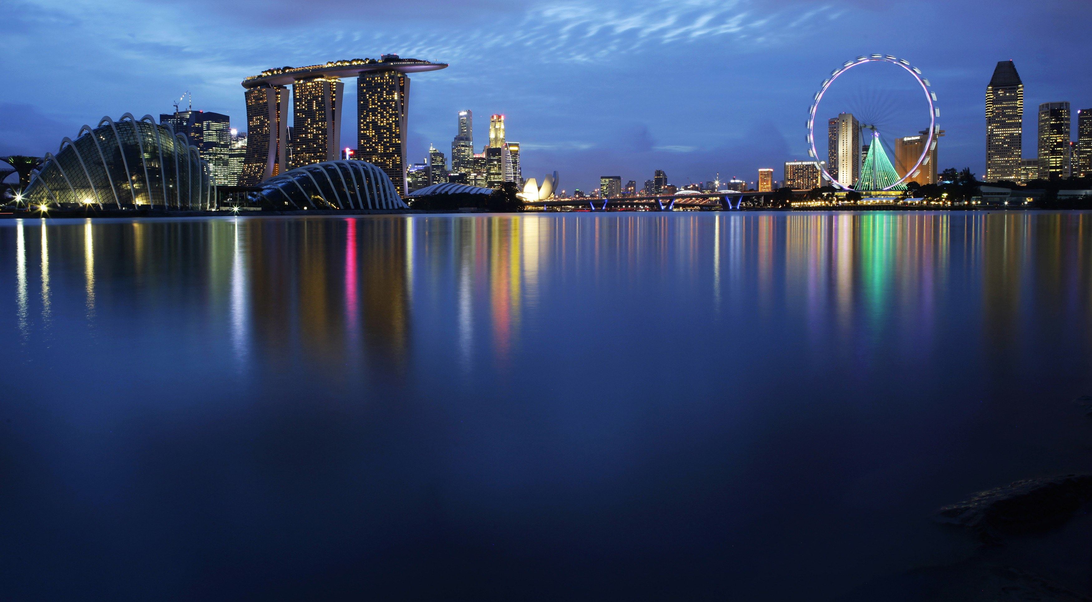 Lights of Singapore’s skyline and Marina Bay are reflected in the waters of the Marina Barrage. Photo: Reuters