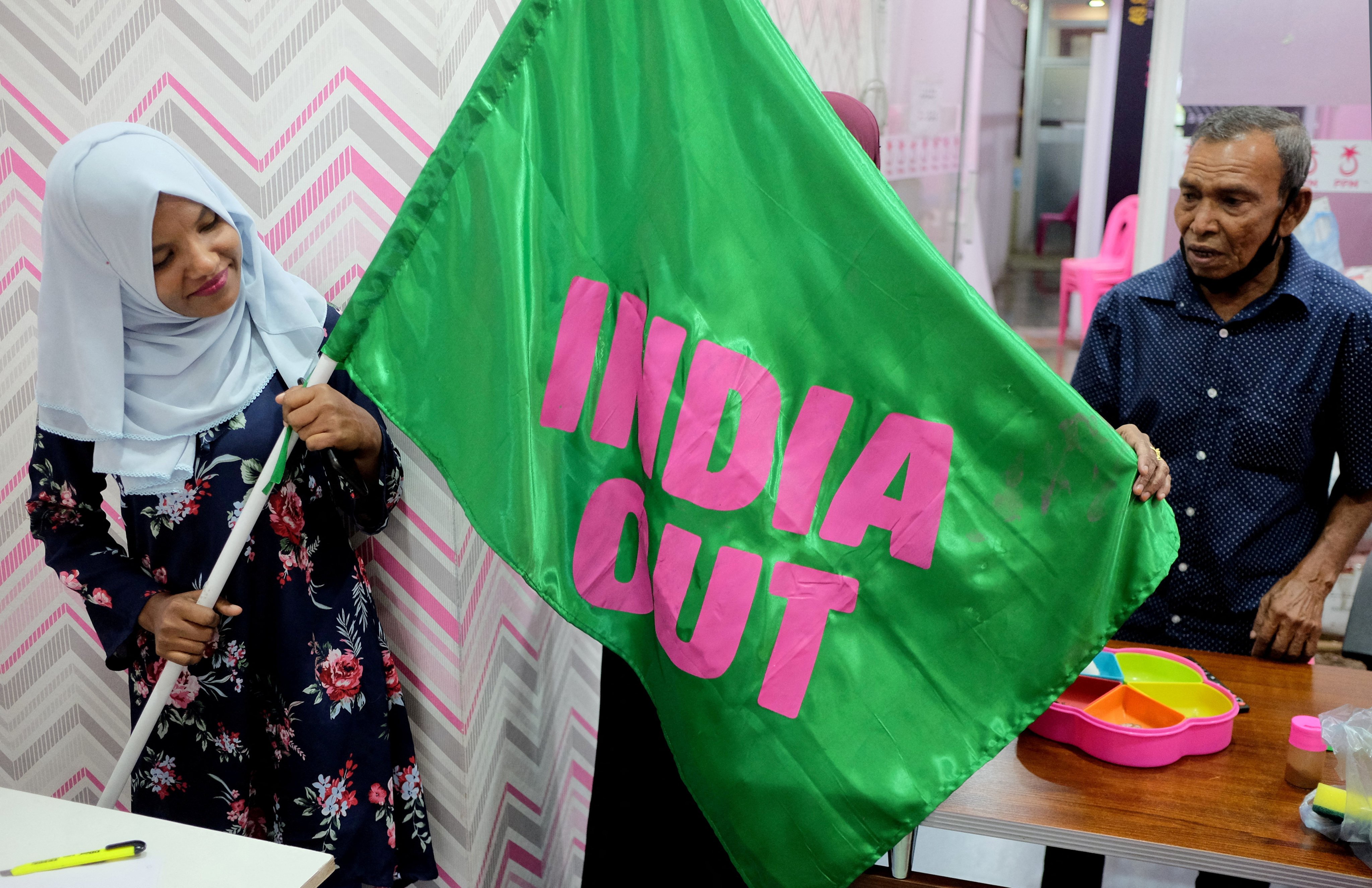 A worker with Mohamed Muizzu’s Progressive Party of Maldives poses with an “India Out” flag in Male last year. Photo: Reuters