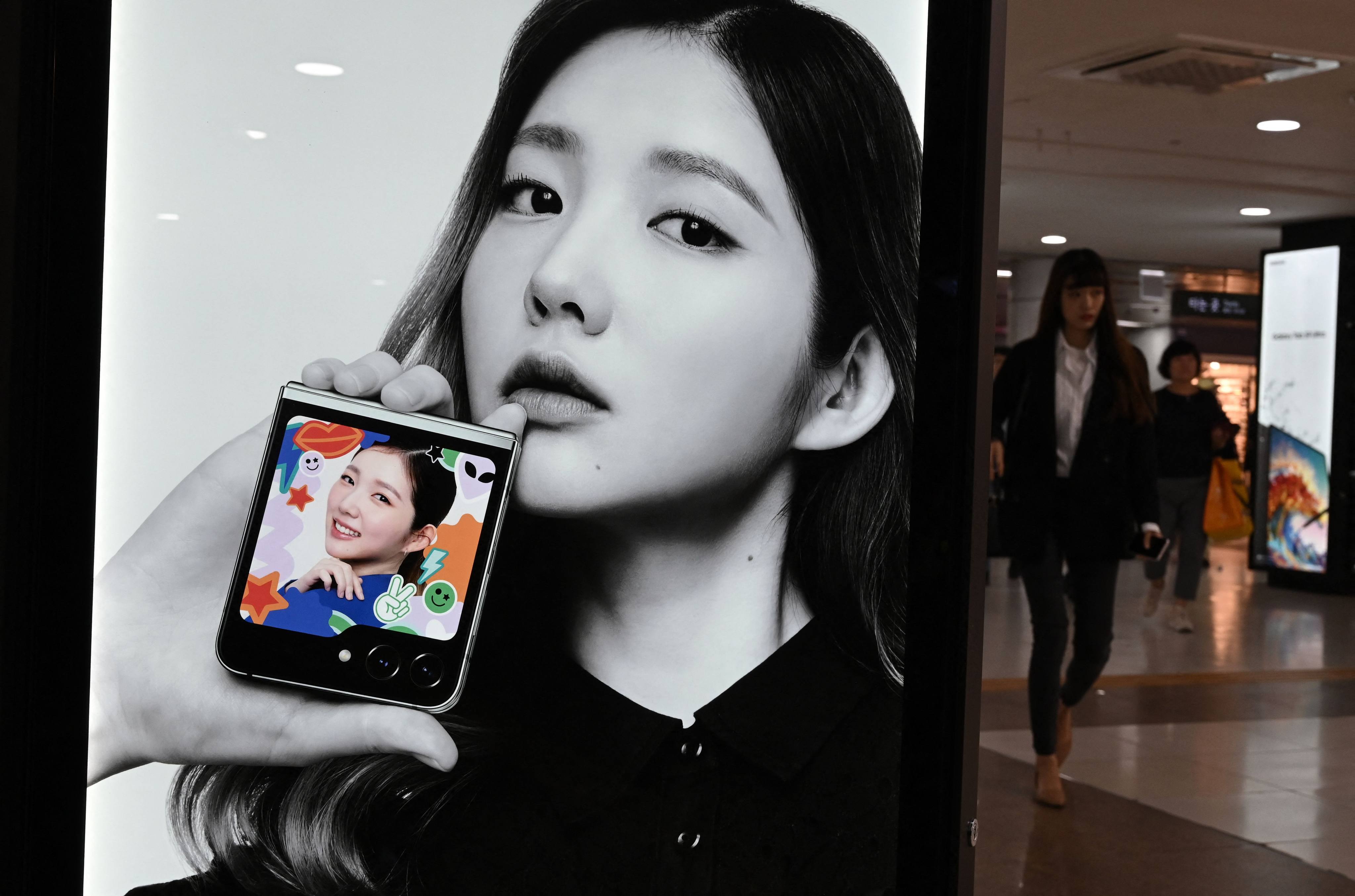 A woman walks past an advertisement for Samsung Galaxy Z Flip5 phone at an underground shopping area in Seoul on October 11. In a major concession to Seoul, Washington has granted both Samsung and Hynix an indefinite waiver on broad restrictions to export advanced chip-making equipment to the mainland. Photo: AFP