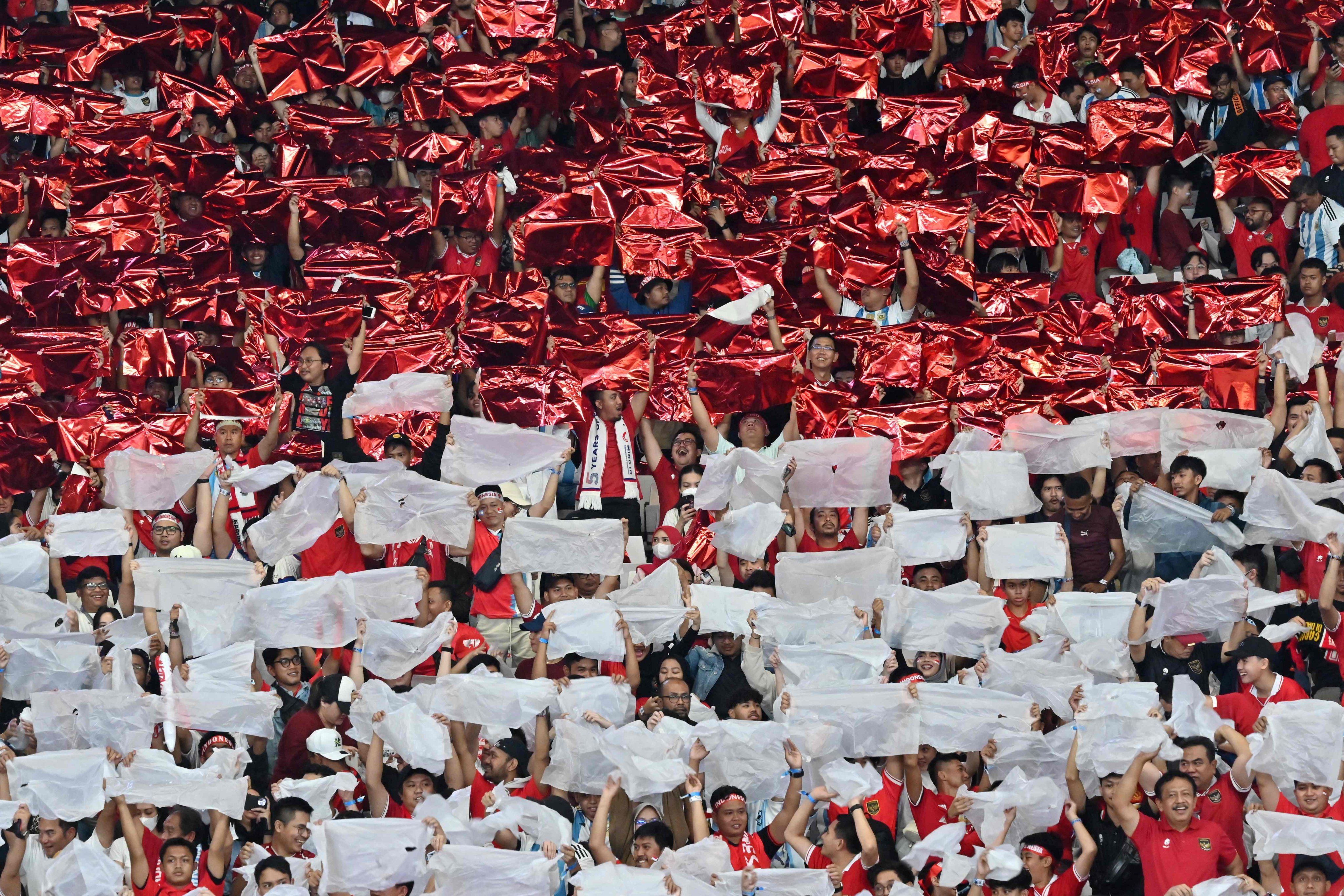 Indonesia’s fans hold papers featuring Indonesia’s national flag during a international friendly against Argentina in Jakarta on June 19, 2023. Photo: AFP