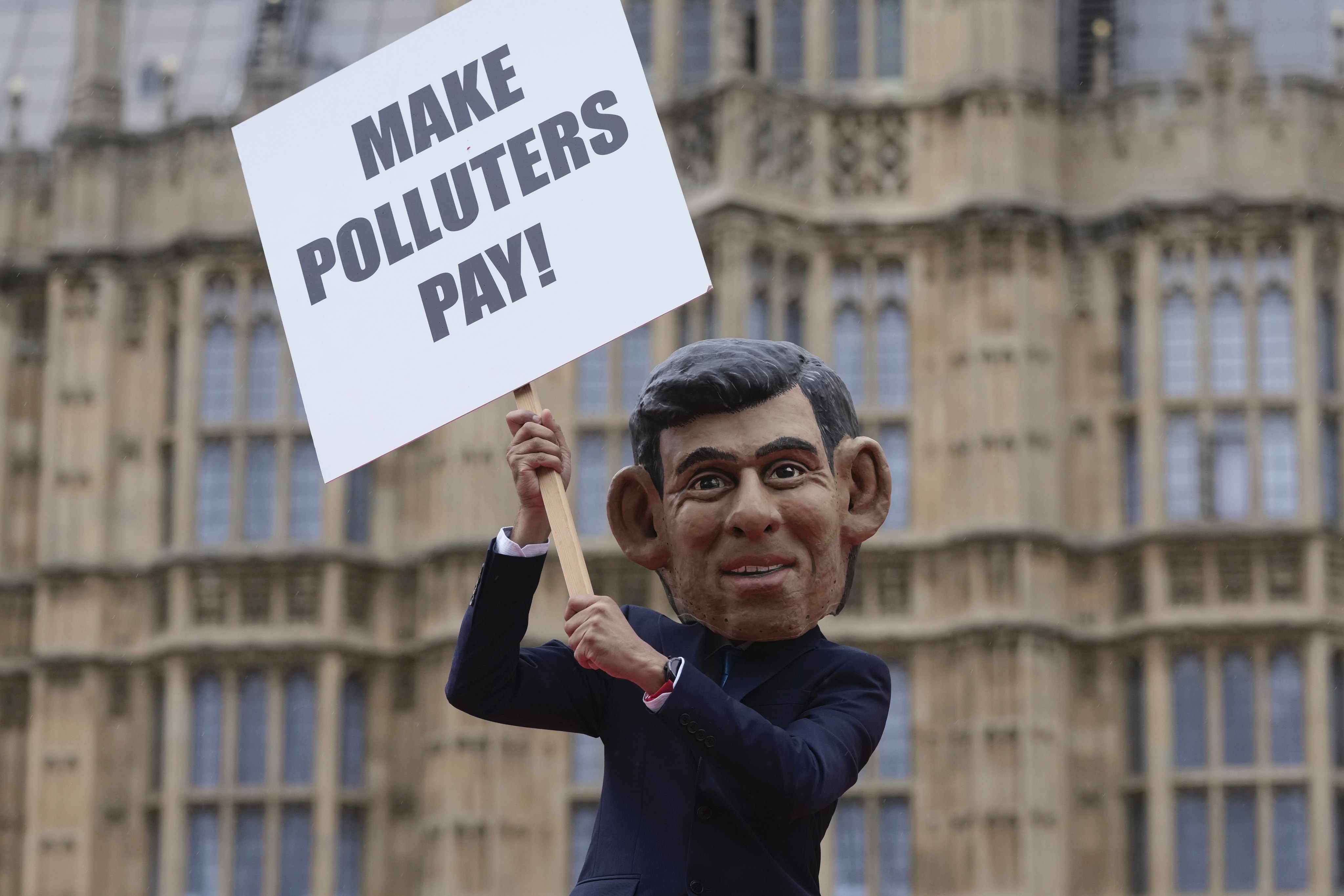 An Oxfam protester in a Rishi Sunak mask outside parliament in London on September 19, on the eve of the UN Climate Ambition Summit, calling for oil and gas giants to pay more tax to raise critical funds to help communities devastated by climate change. Photo: AP