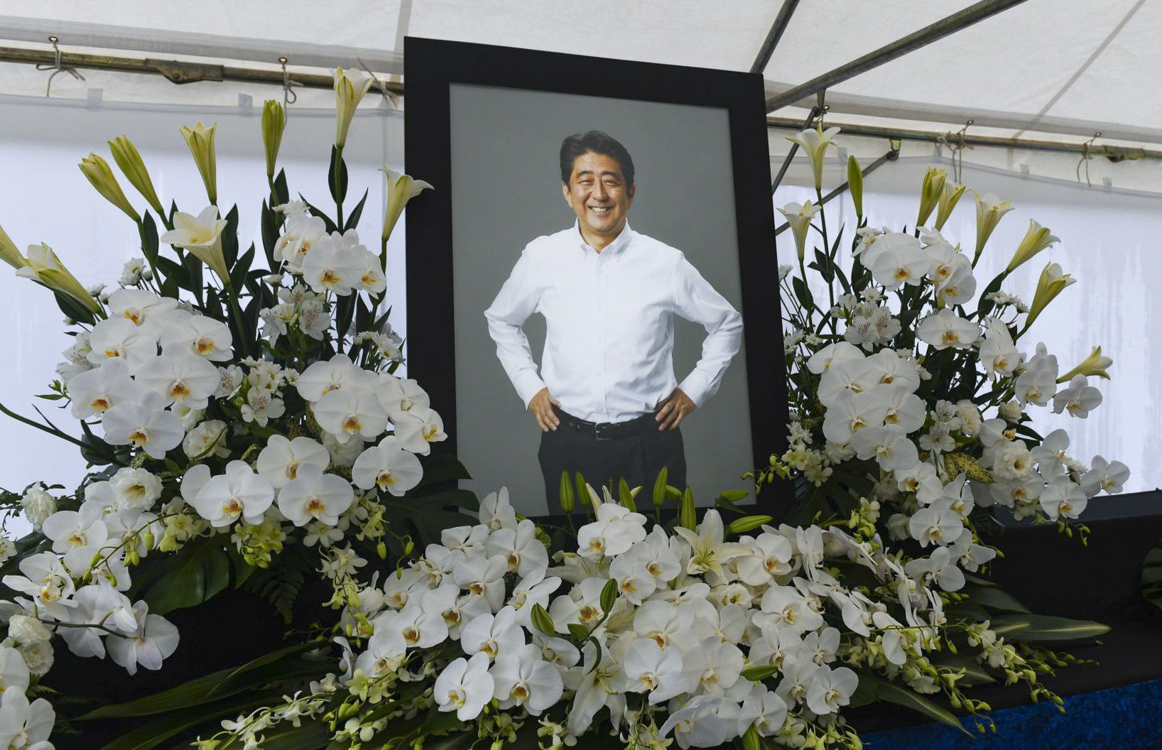 A photograph of former Prime Minister Shinzo Abe at a makeshift memorial at Zojoji temple in Tokyo, Japan, on Tuesday, July 12, 2022. A private funeral was held Tuesday for Abe, whose assassination last week shocked a nation and brought renewed attention to his key policies such as bolstering the nation’s defenses. Photographer: Noriko Hayashi/Bloomberg