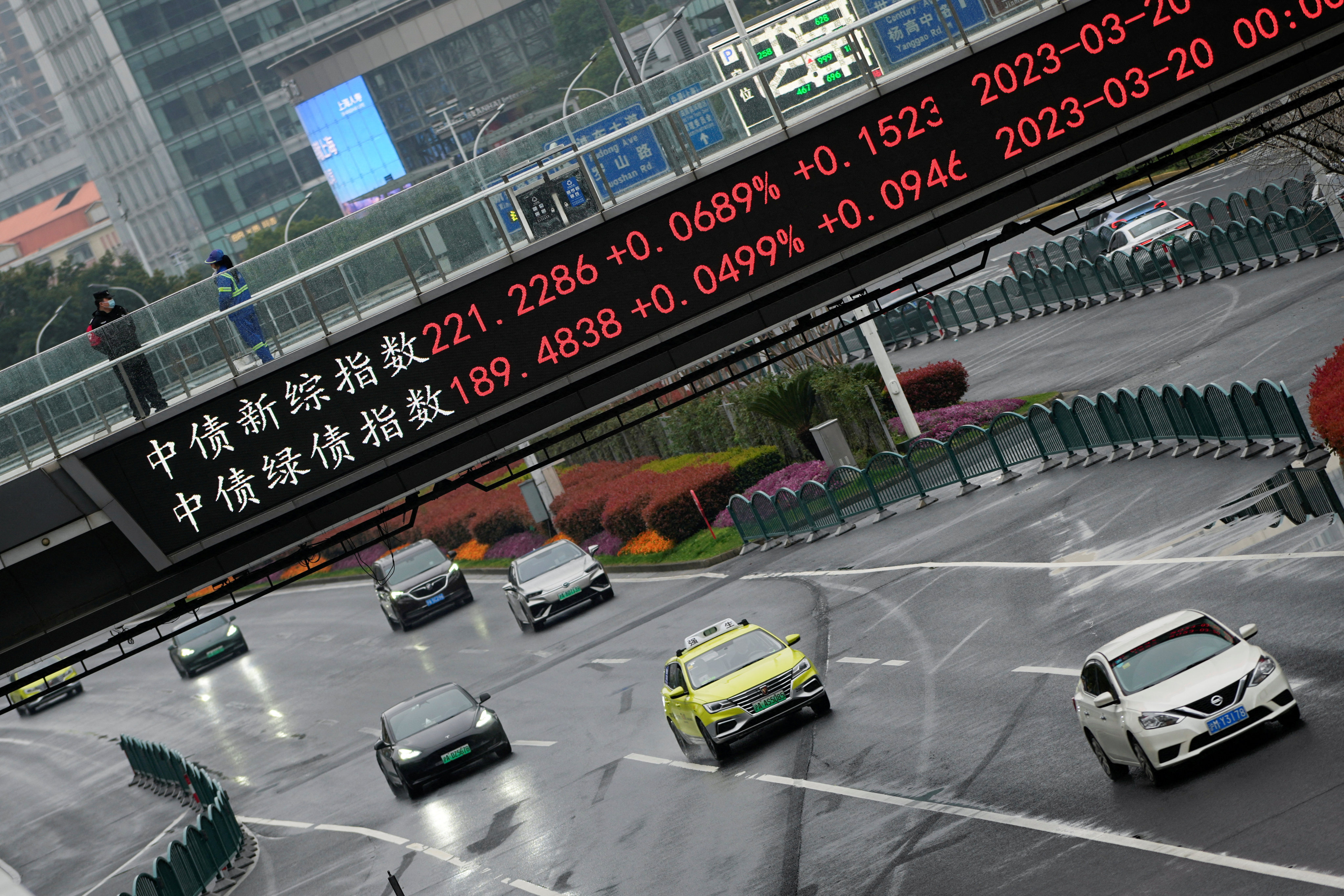An electronic board shows stock indices on an overhead bridge in Shanghai in March 2023. Photo: Reuters