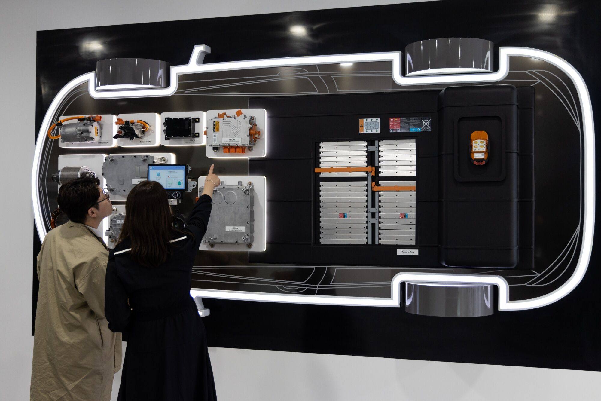 People look at a display of an electric vehicle power train, including a battery pack. Photo: Bloomberg