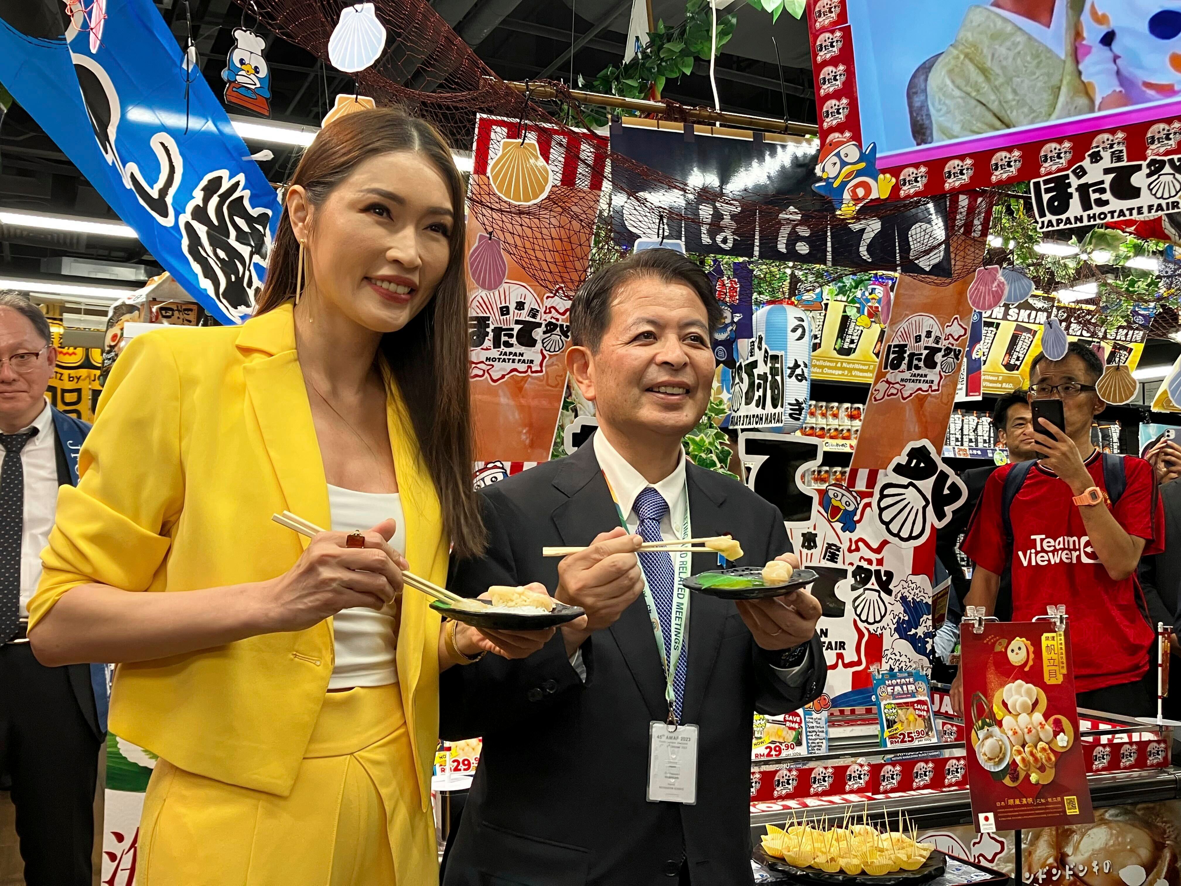 Japanese Agriculture Minister Ichiro Miyashita and Malaysian celebrity Amber Chia promote Japanese scallops to shoppers at a Don Don Donki outlet in Kuala Lumpur on October 4. Photo: AP