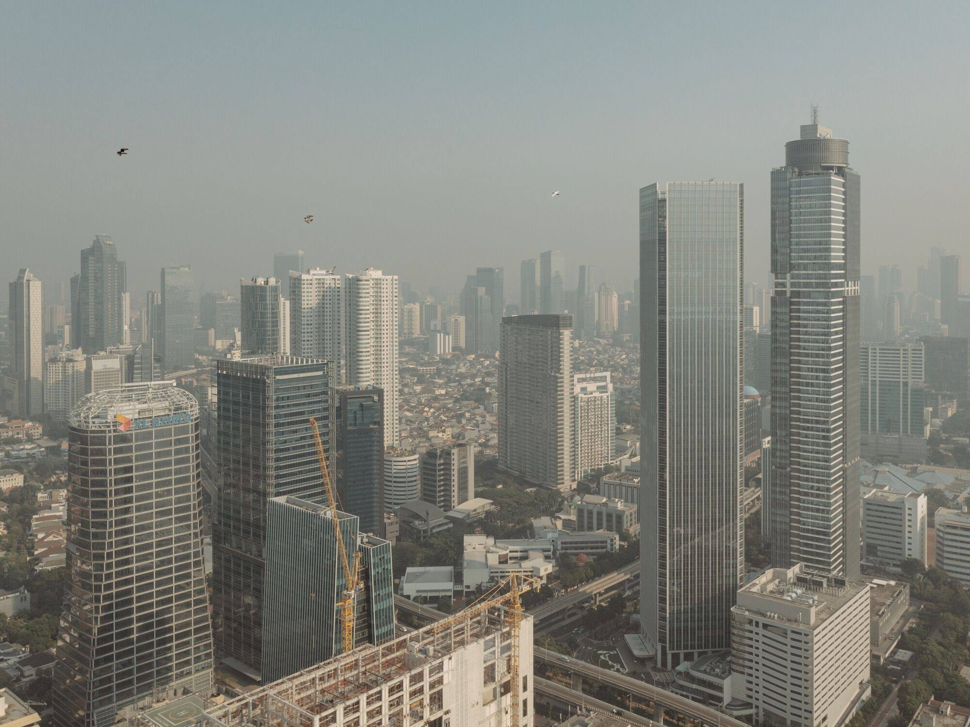 Buildings shrouded in smog in Jakarta. Southeast Asia, according to one estimate by the Asian Development Bank, requires US$210 billion annually through 2030 for climate infrastructure investment. Photo: Bloomberg