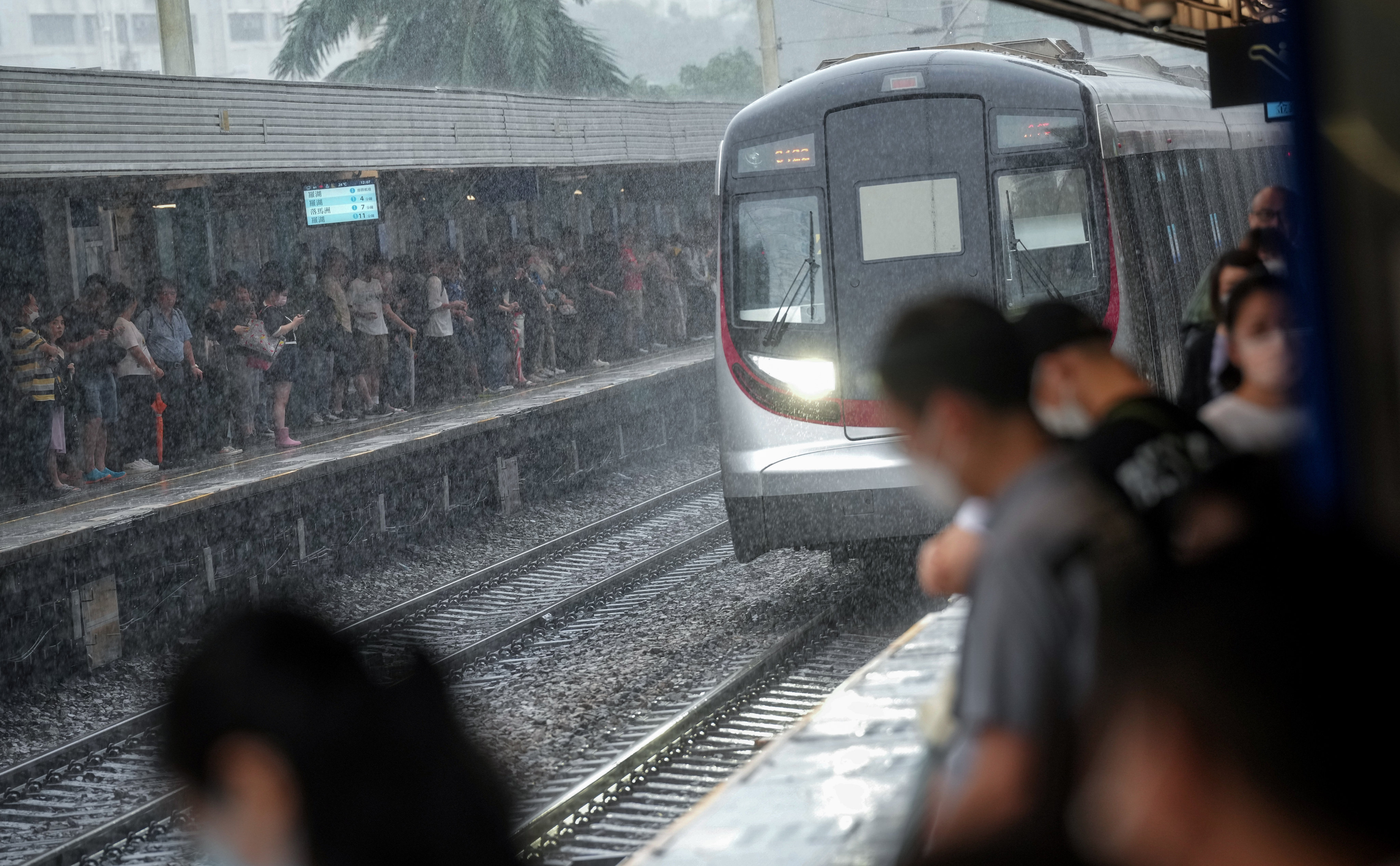Open-air rail services under a No 9 or more typhoon alert in Hong Kong have to shut down, meaning airport arrivals have no way into the city except to scramble for taxis willing to operate in extreme weather. Photo: Elson LI