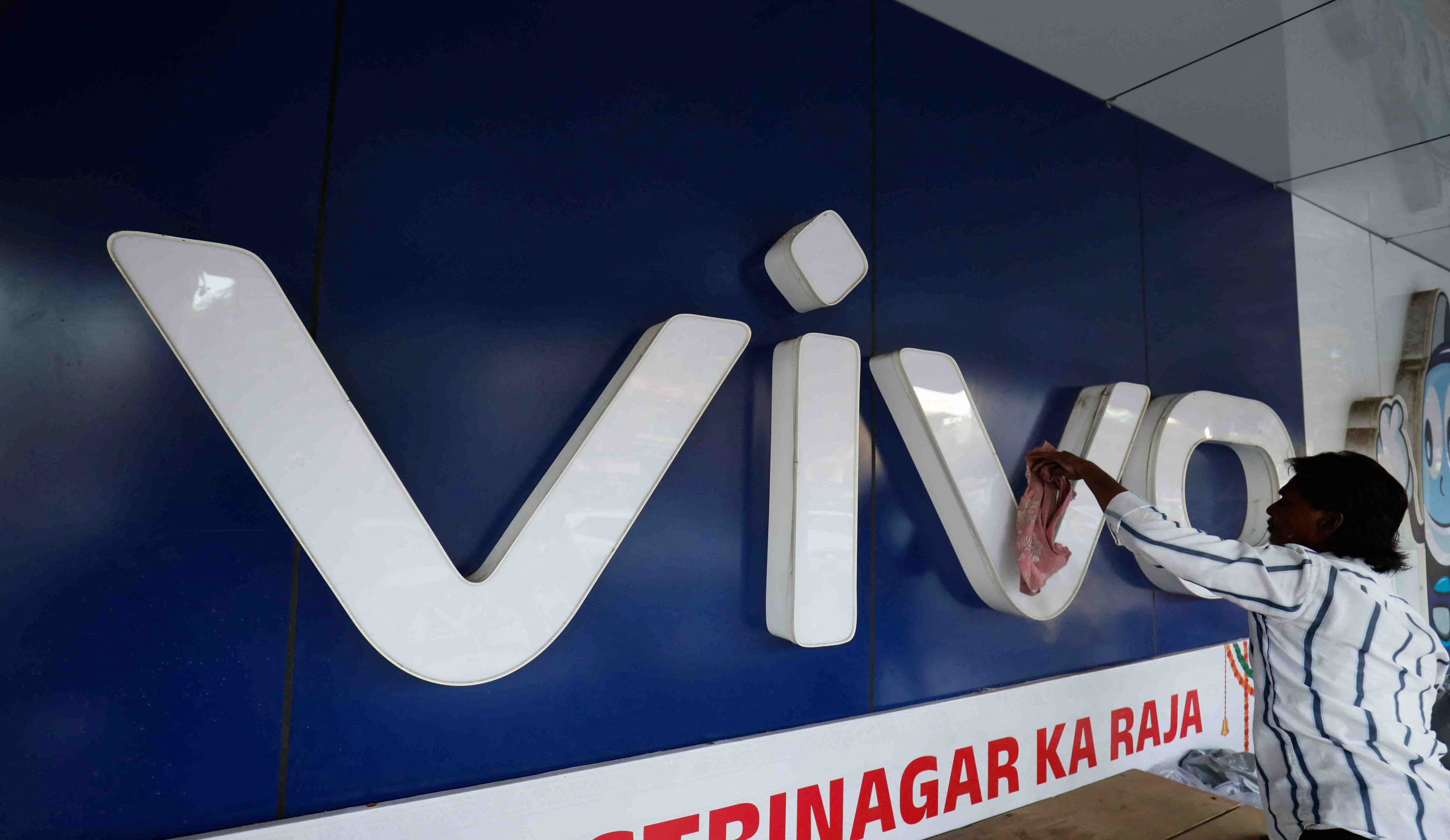 A man cleans the logo of Chinese smartphone company Vivo outside a store in Ahmedabad, India, on October 10. Officially, India is open to Chinese business. But the government has used various measures to make Chinese firms’ lives in India difficult or impossible. Photo: Reuters 
