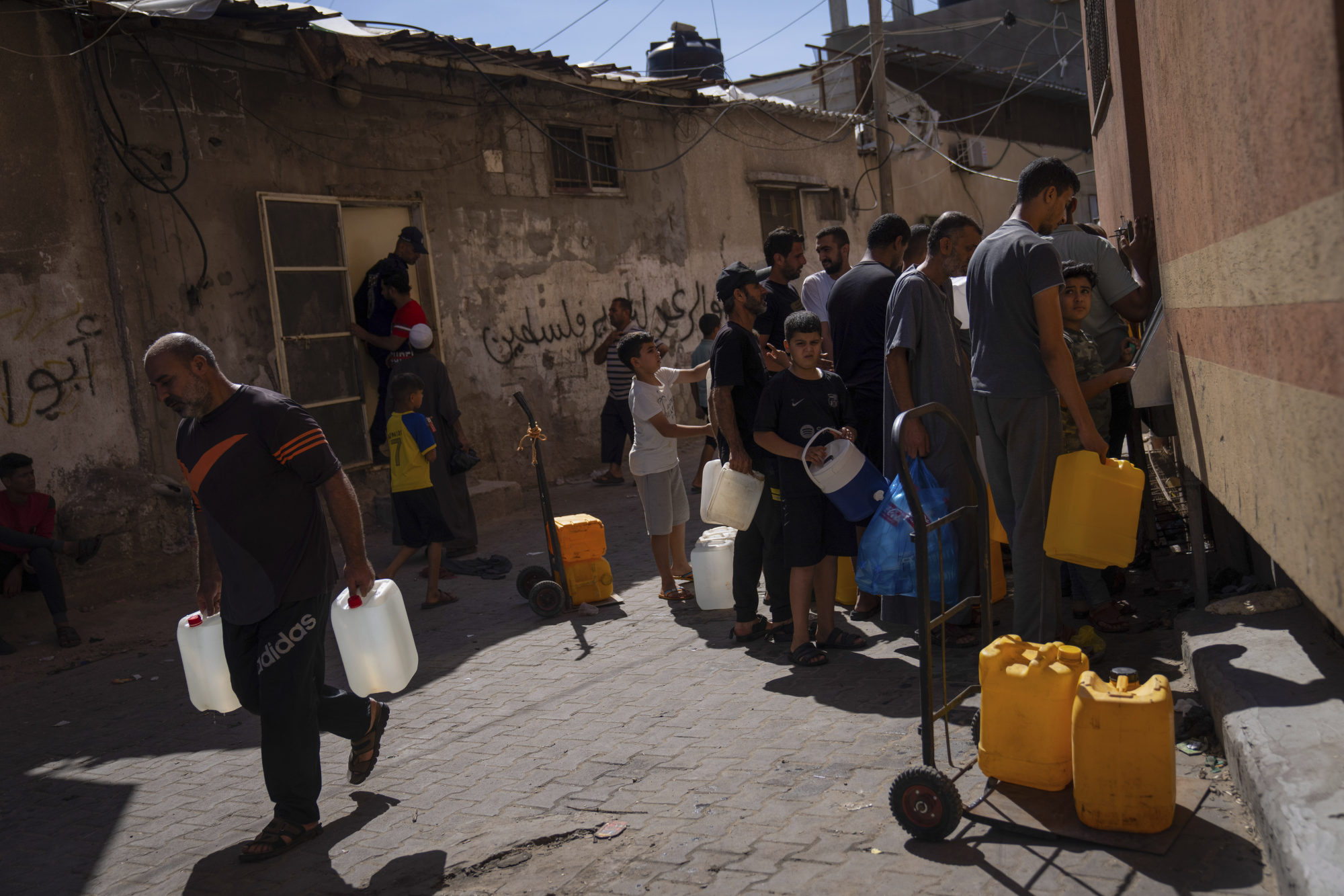 Palestinians collect water from a tap, amid drinking water shortages in Khan Younis, Gaza Strip on Sunday. Photo: AP