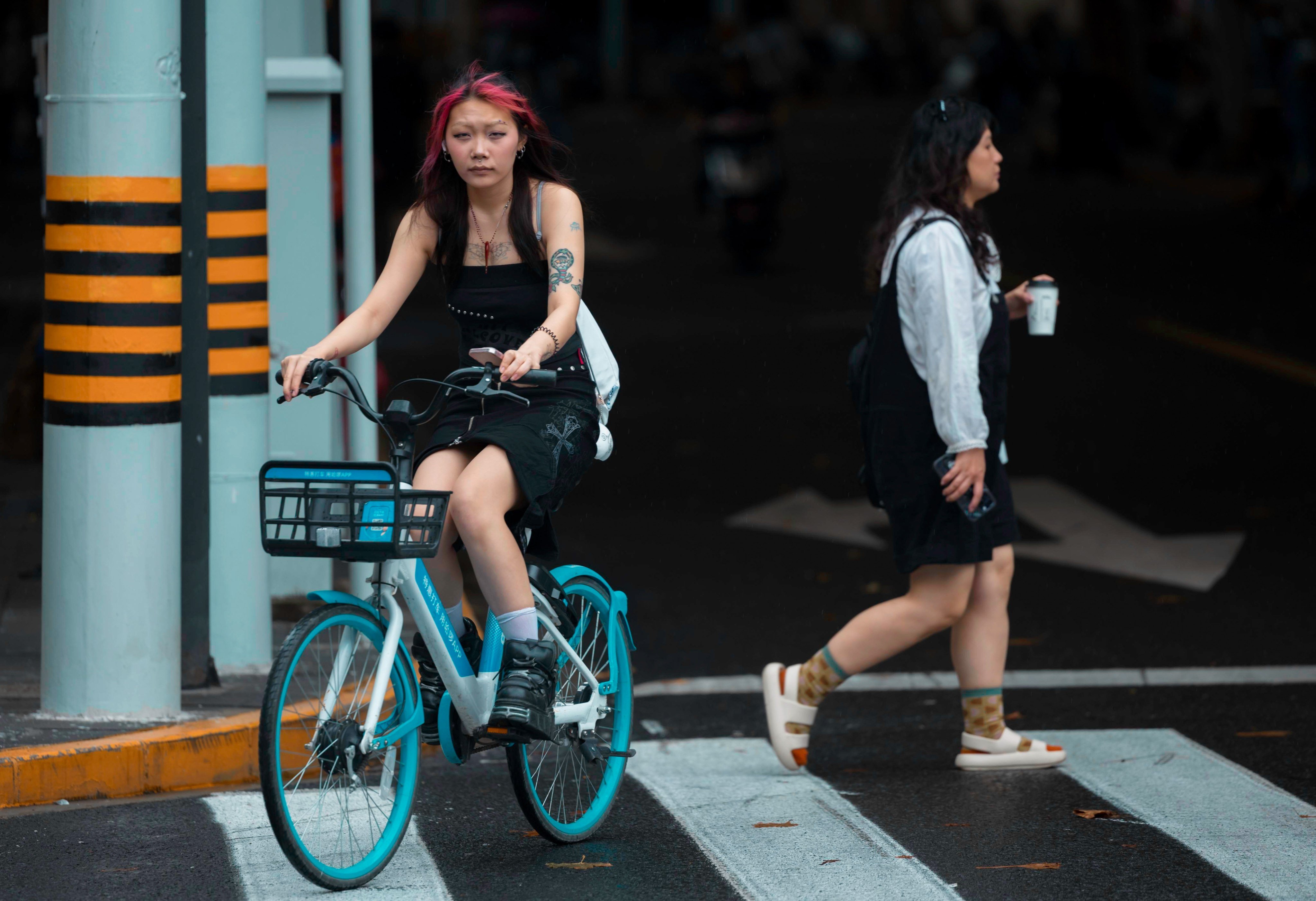 A young woman rides a bicycle in Shanghai on September 14. Already grappling with high youth unemployment amid a surplus of university graduates, China should carefully consider the impact of its localisation policies. Photo: EPA-EFE