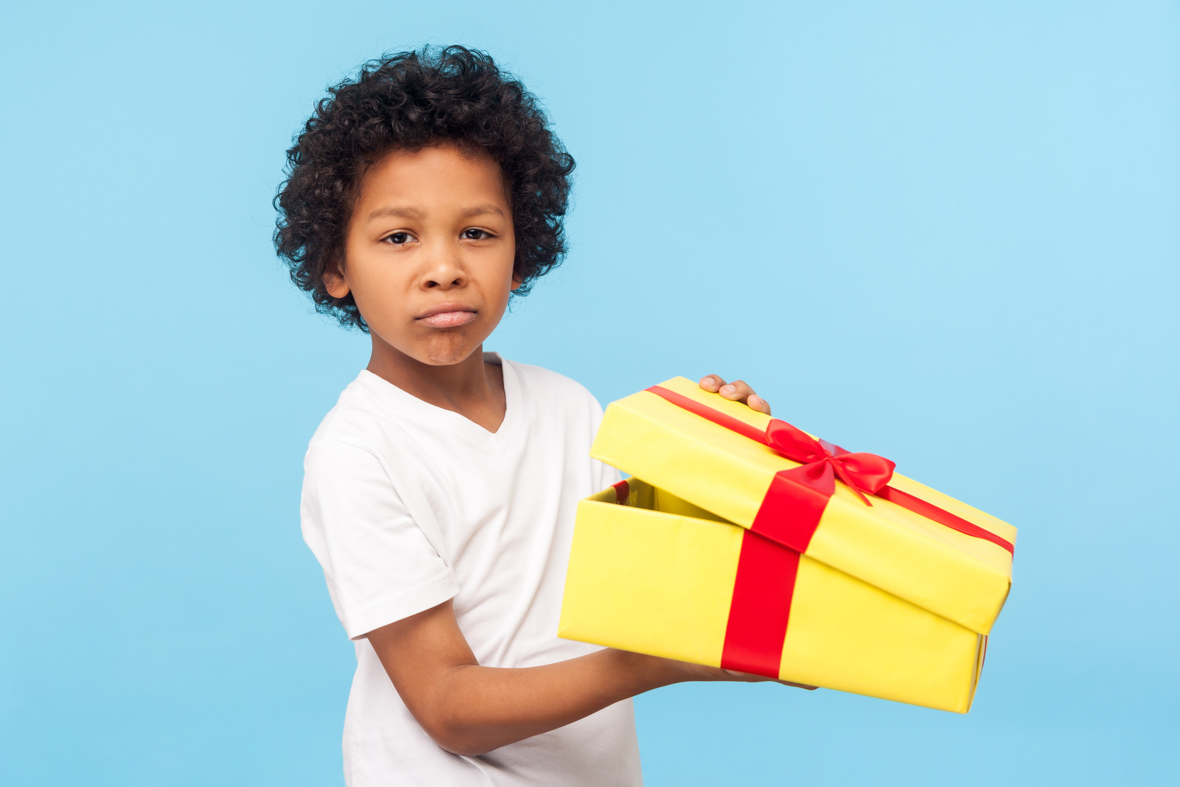 First presents. Ребенок недоволен подарком. Мальчик держит коробку с конструктором. Мальчик держит коробку лего.