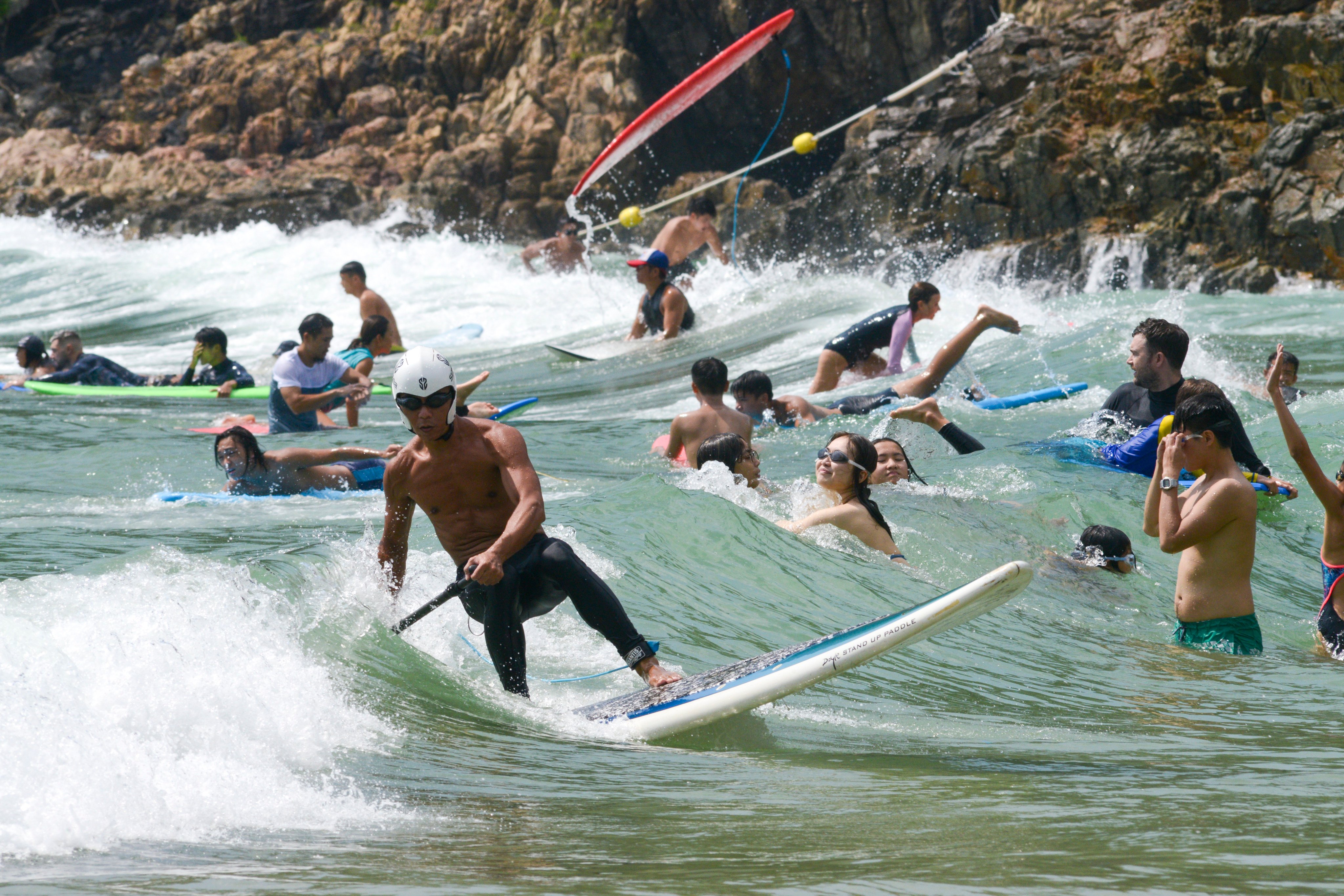 People enjoy the sun and surf at Big Wave Bay, Hong Kong, on October 9, 2022. There has been an explosion in the use of water sports equipment such as surfboards, canoes, stand-up paddle boards, and sailing and rowing boats. Photo: Antony Dickson