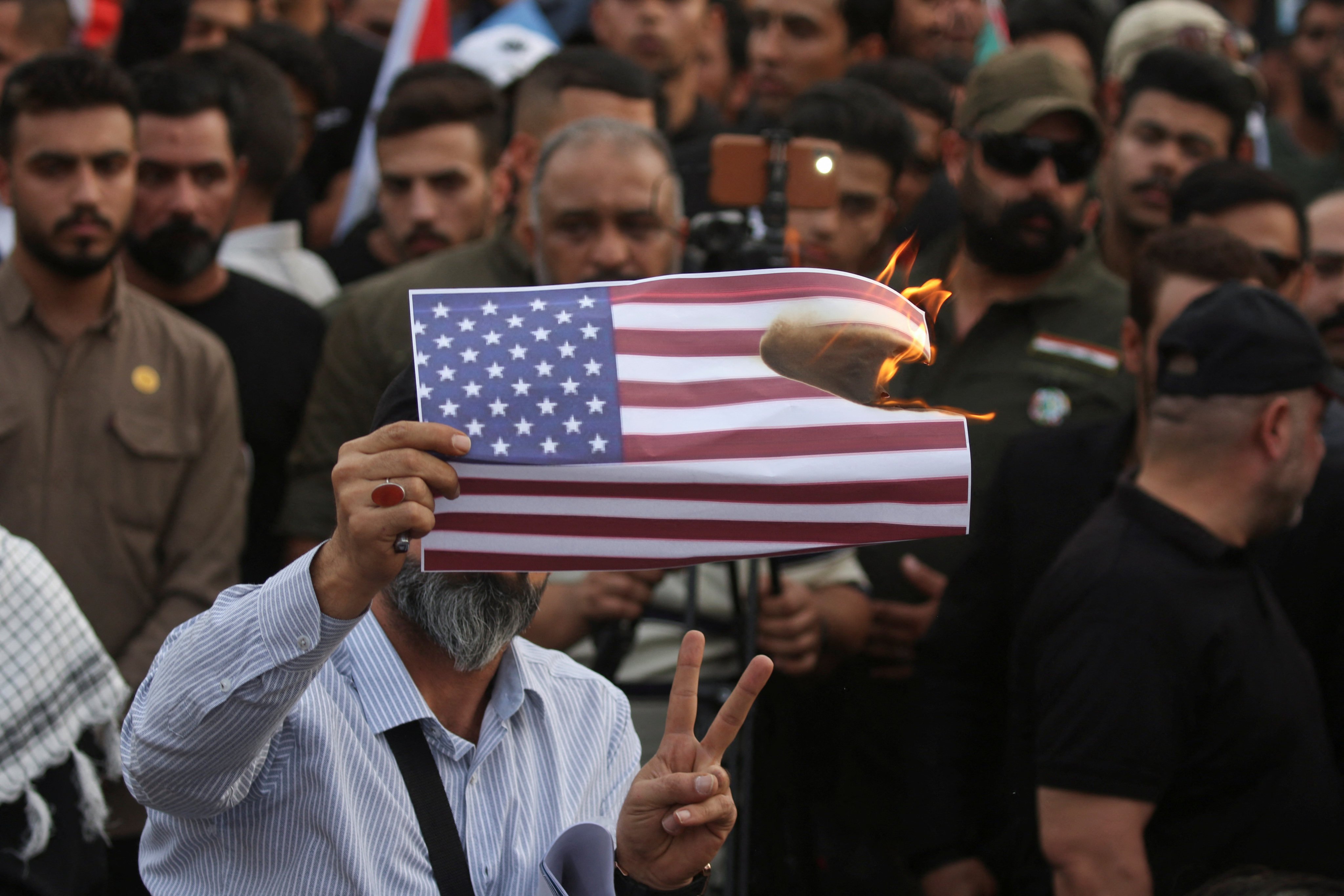A demonstrator burns a copy of an American flag, as supporters of Iraqi Shi’ite armed groups gather to protest against the US for supporting Israel, and in support of Palestinians in Gaza. Photo: Reuters