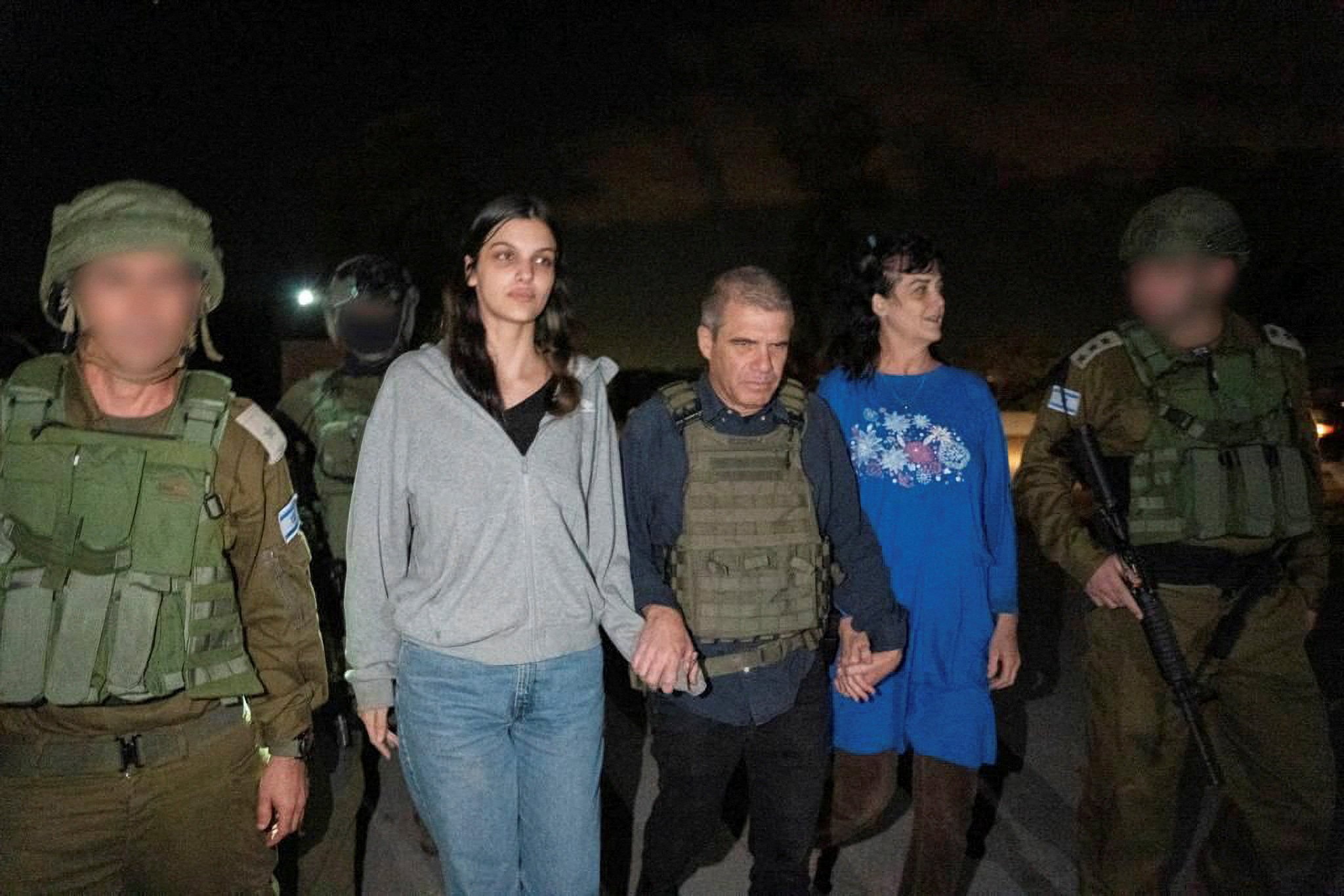 Judith Raanan and her daughter Natalie, US citizens who were taken as hostages by Hamas militants, walk while holding hands with Brigadier-General (Retired) Gal Hirsch, Israel’s coordinator for the captives and missing, after they were released. Photo: Government of Israel via Reuters