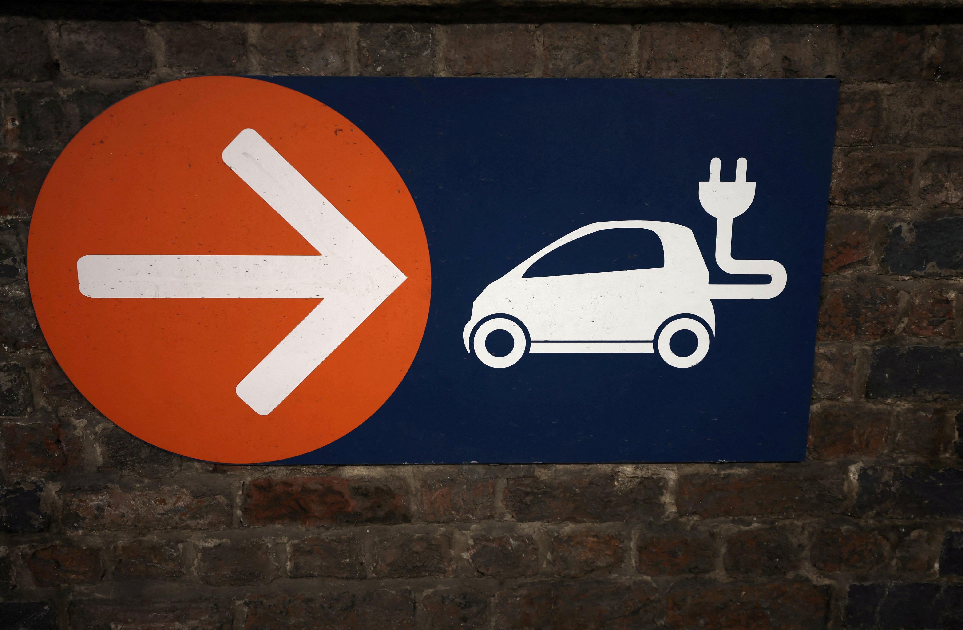 A sign directing the way towards electric vehicle charging points is seen in a car park in Manchester, Britain, on September 8. Photo: Reuters 